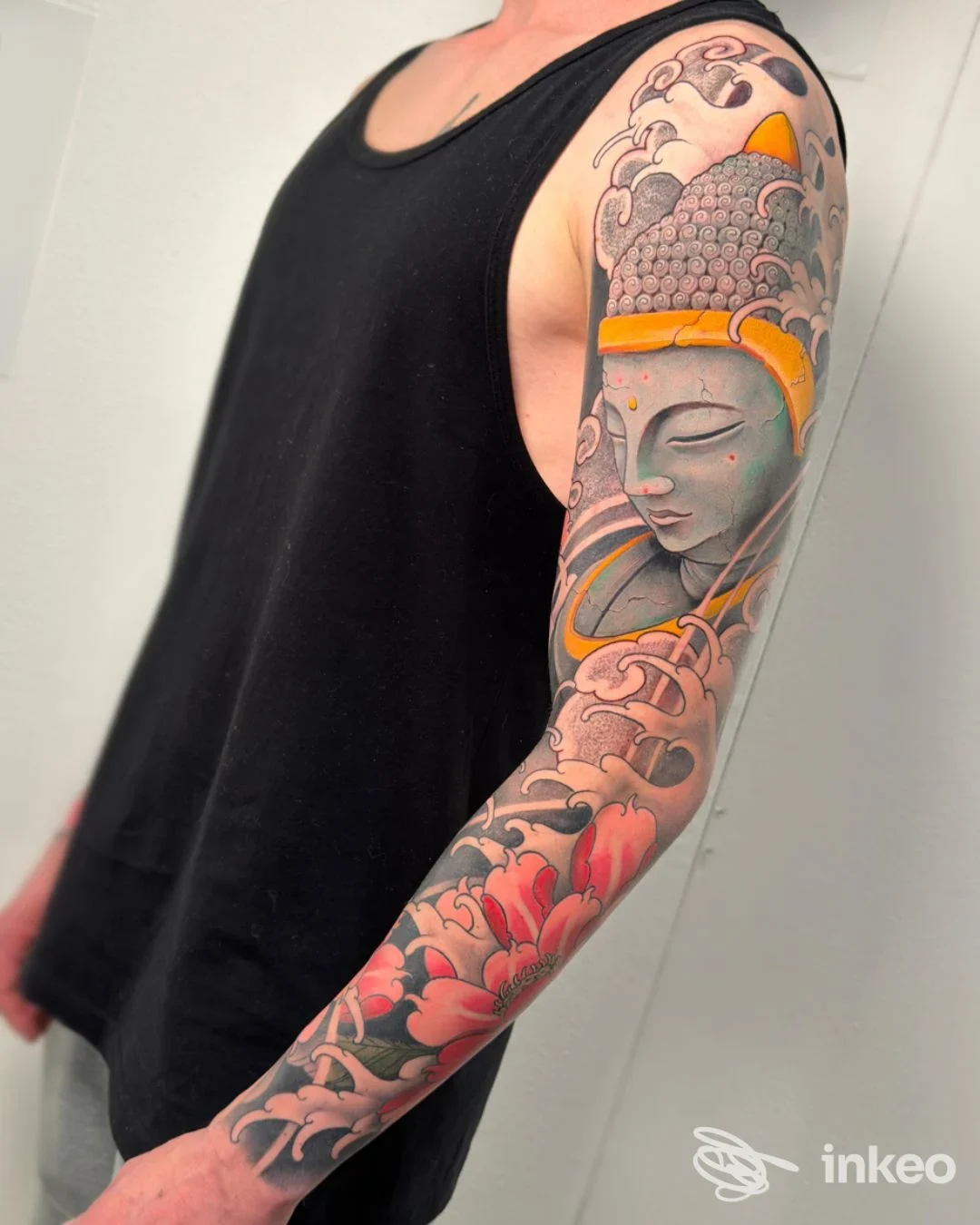Manica completa tatuata con figura buddista, onde e fiori, foto di Nova Studio Tattoo & Piercing, Jesi.