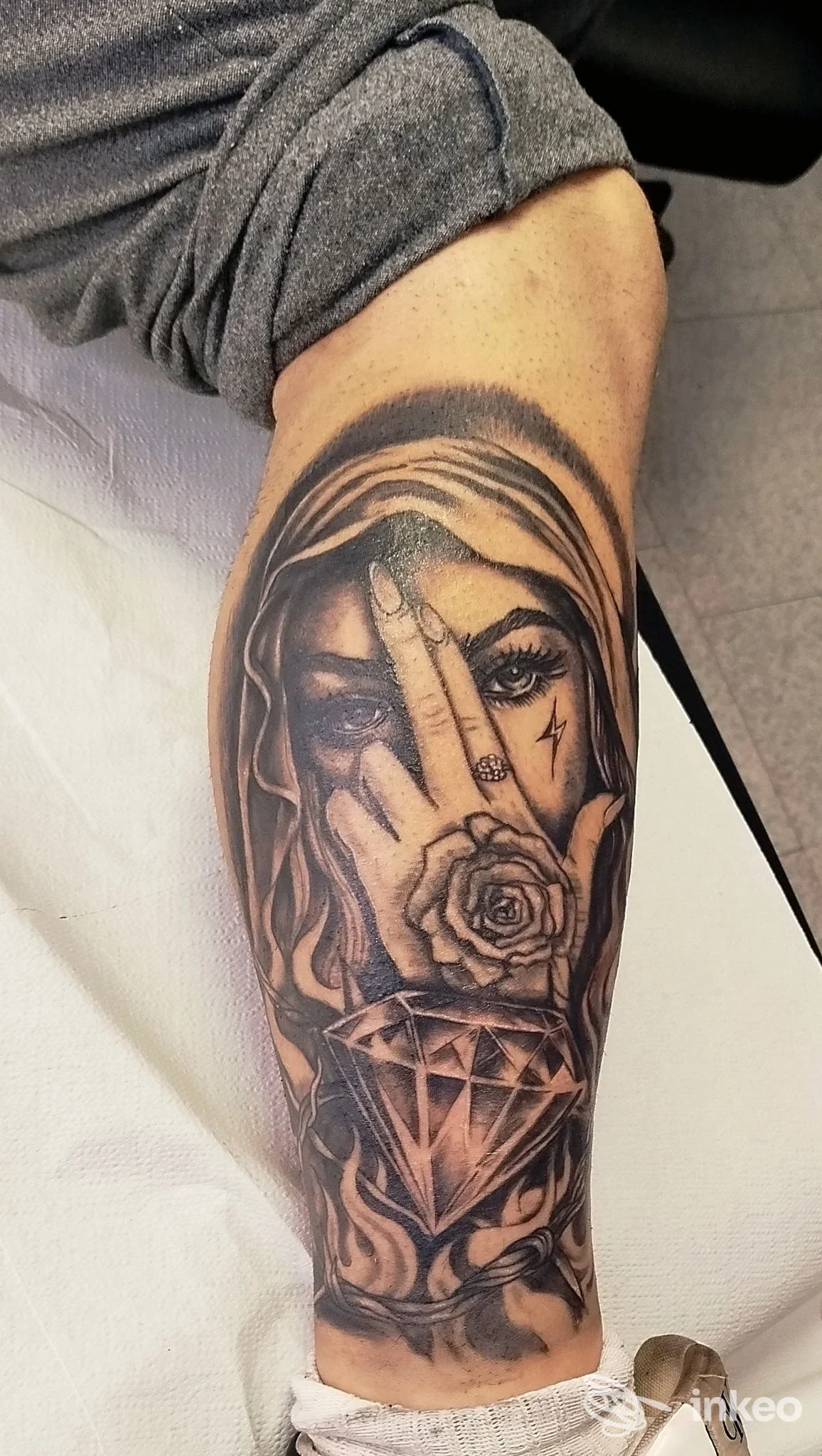 Tatuaggio black & grey sull'avambraccio con volto velato, rosa e diamante — immagine per SETTANTA7 TATTOO STUDIO a Castelraimondo.