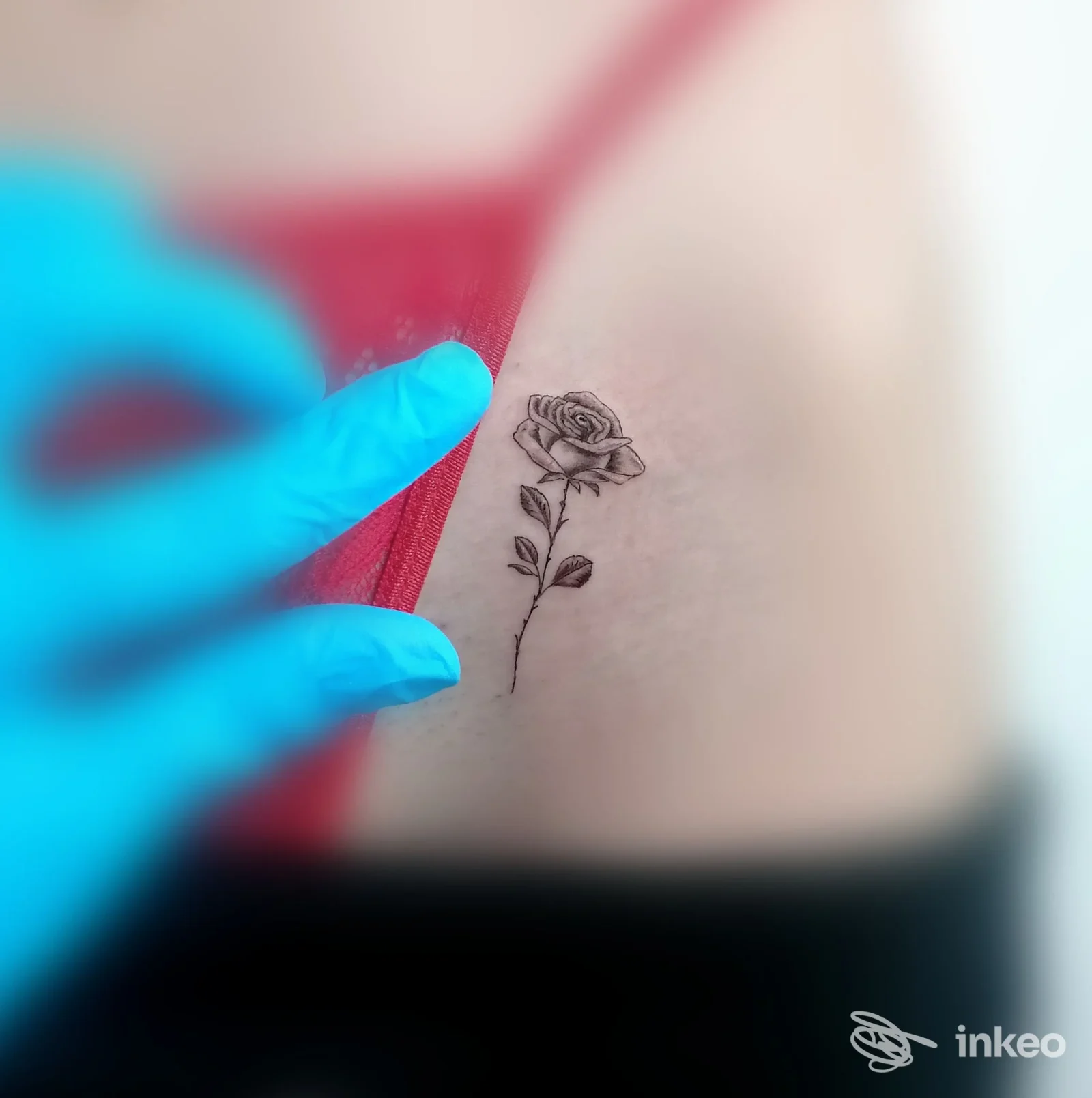 Piccolo tatuaggio a rosa sul costato in bianco e nero, dettaglio mostrato dallo studio STONE TATTOO a Sassoferrato.