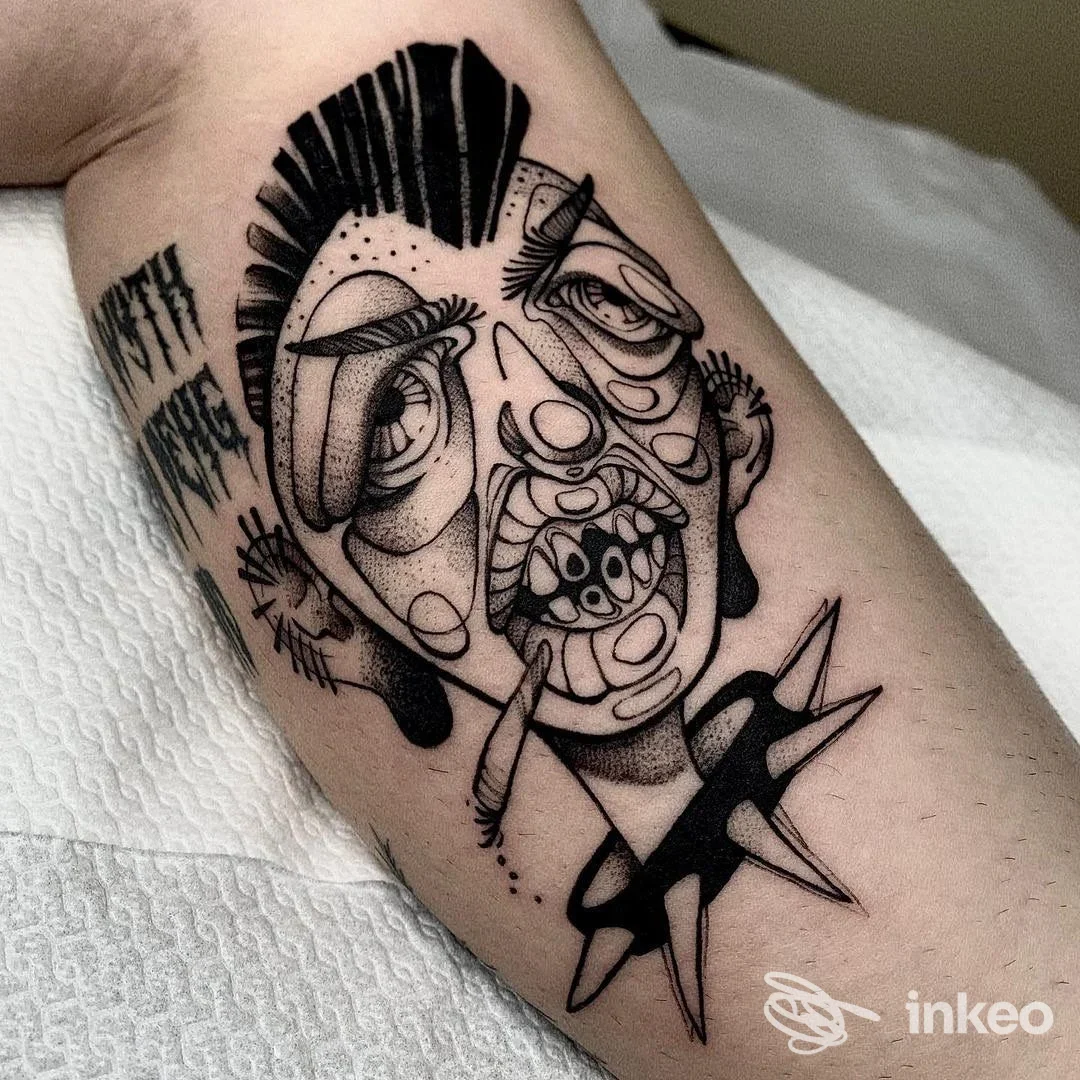 Tatuaggio blackwork stilizzato su avambraccio con volto grottesco, Snatch Tattoo & Piercing, Osimo.