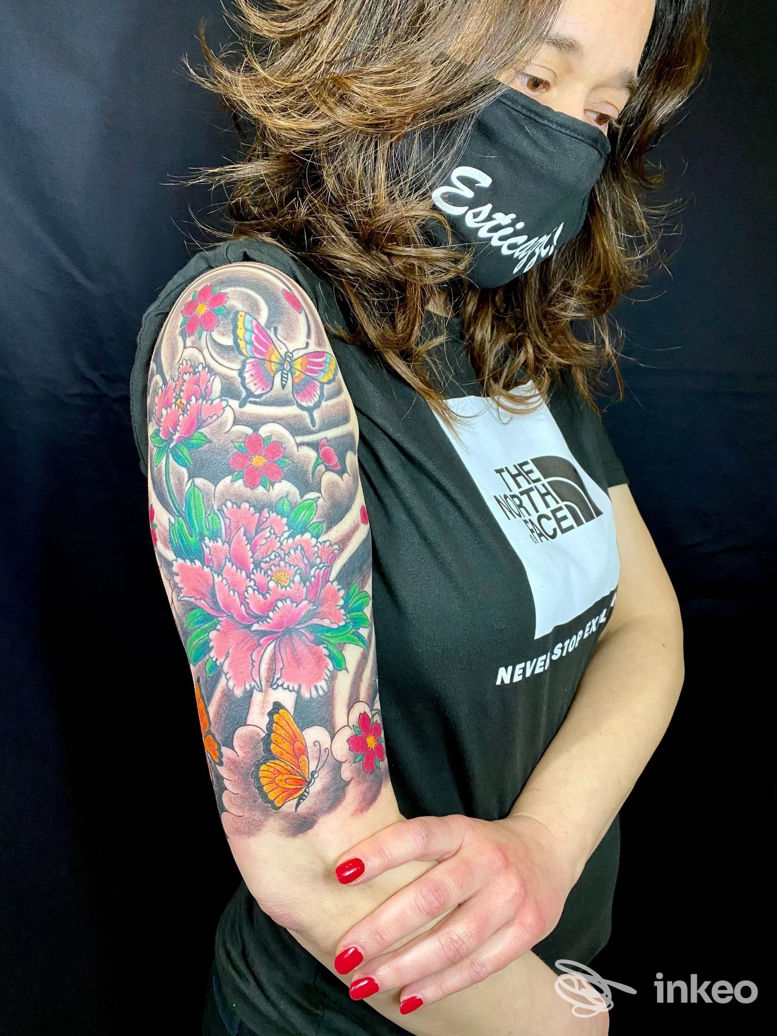 Donna con tatuaggio floreale e farfalle sul braccio superiore, foto realizzata da Stiff Tattoo, San Benedetto del Tronto.