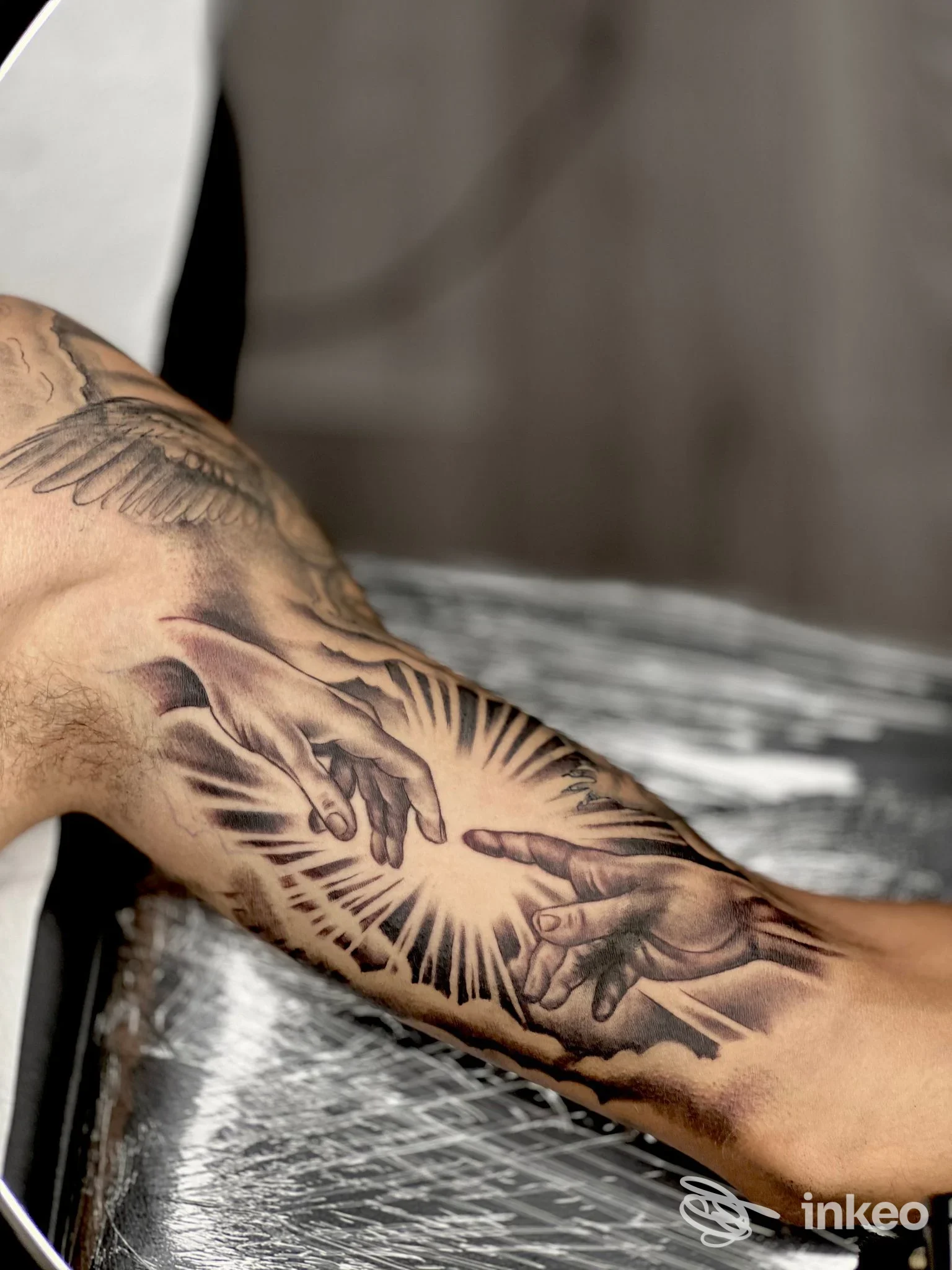 Primo piano di tatuaggio realistico sull'avambraccio raffigurante due mani in stile classico; lavoro di Simone Innamorati Tattoo Studio, San Benedetto del Tronto.