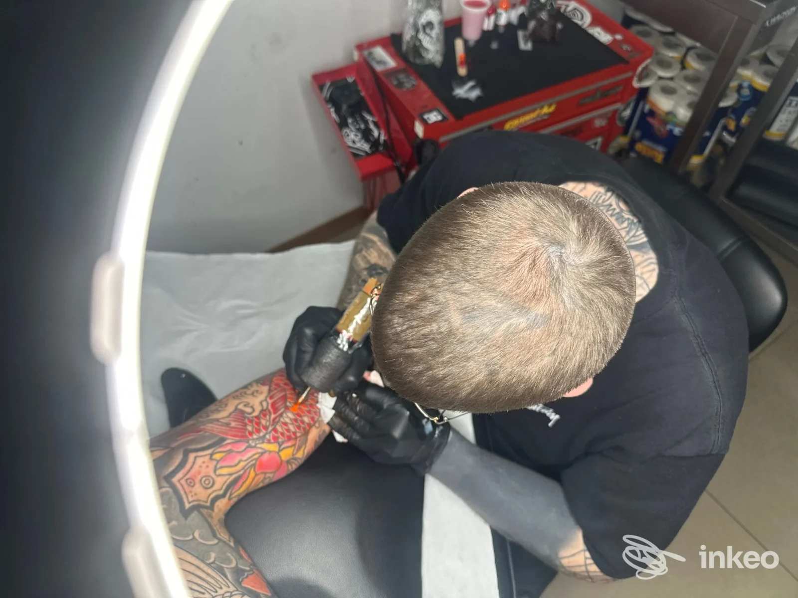 Tatuatore di Tattoo moh a Montelabbate mentre lavora su una gamba tatuata colorata in studio.