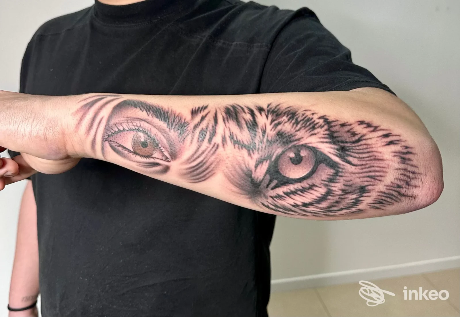 Primo piano di un tatuaggio realistico a forma di occhi di tigre sull'avambraccio, lavoro di Tattoo moh a Montelabbate.