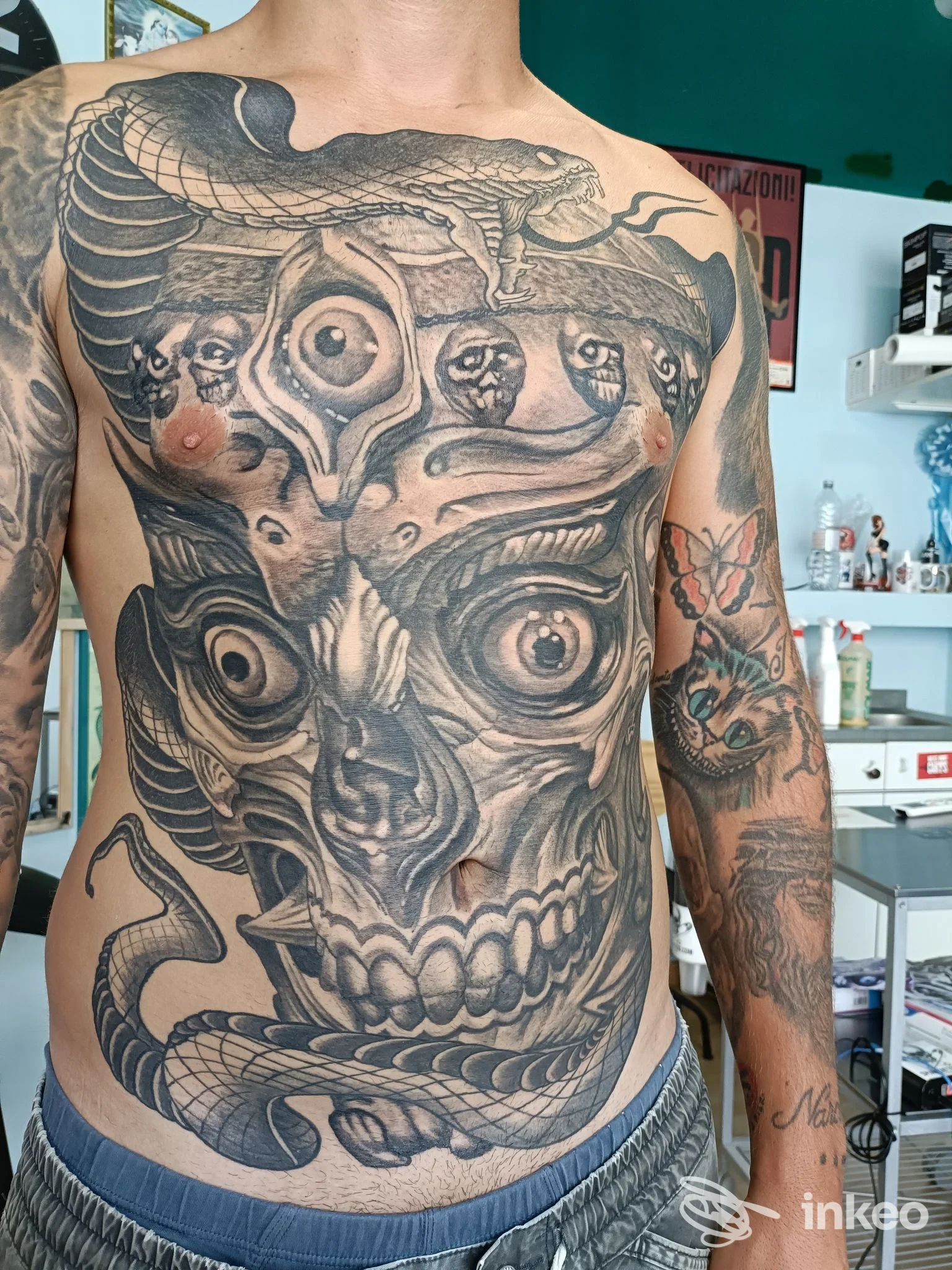 Ampio tatuaggio in bianco e nero con teschio e serpenti su torace e addome, eseguito presso Tatuaggi SPUNKTATTOO a Civitanova Marche.
