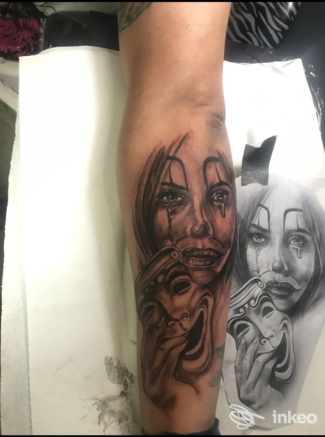 Tatuaggio realistico in nero su avambraccio raffigurante volto piangente e maschere, eseguito da Tatuaggi & Arte a Porto Sant'Elpidio.