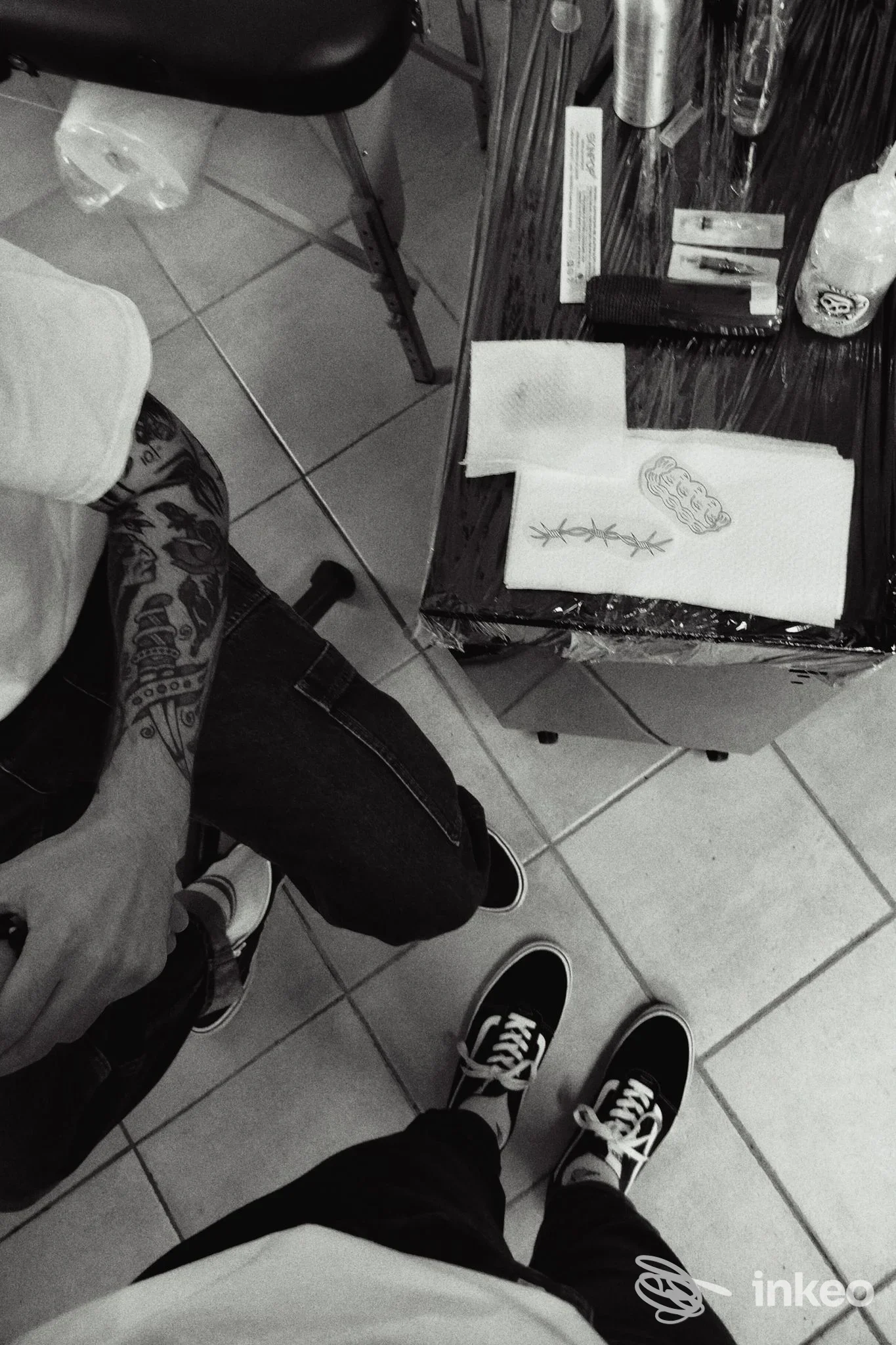 Primo piano in studio su avambraccio tatuato; UnderSkinTattoo Fano visibile sul materiale di lavoro accanto.