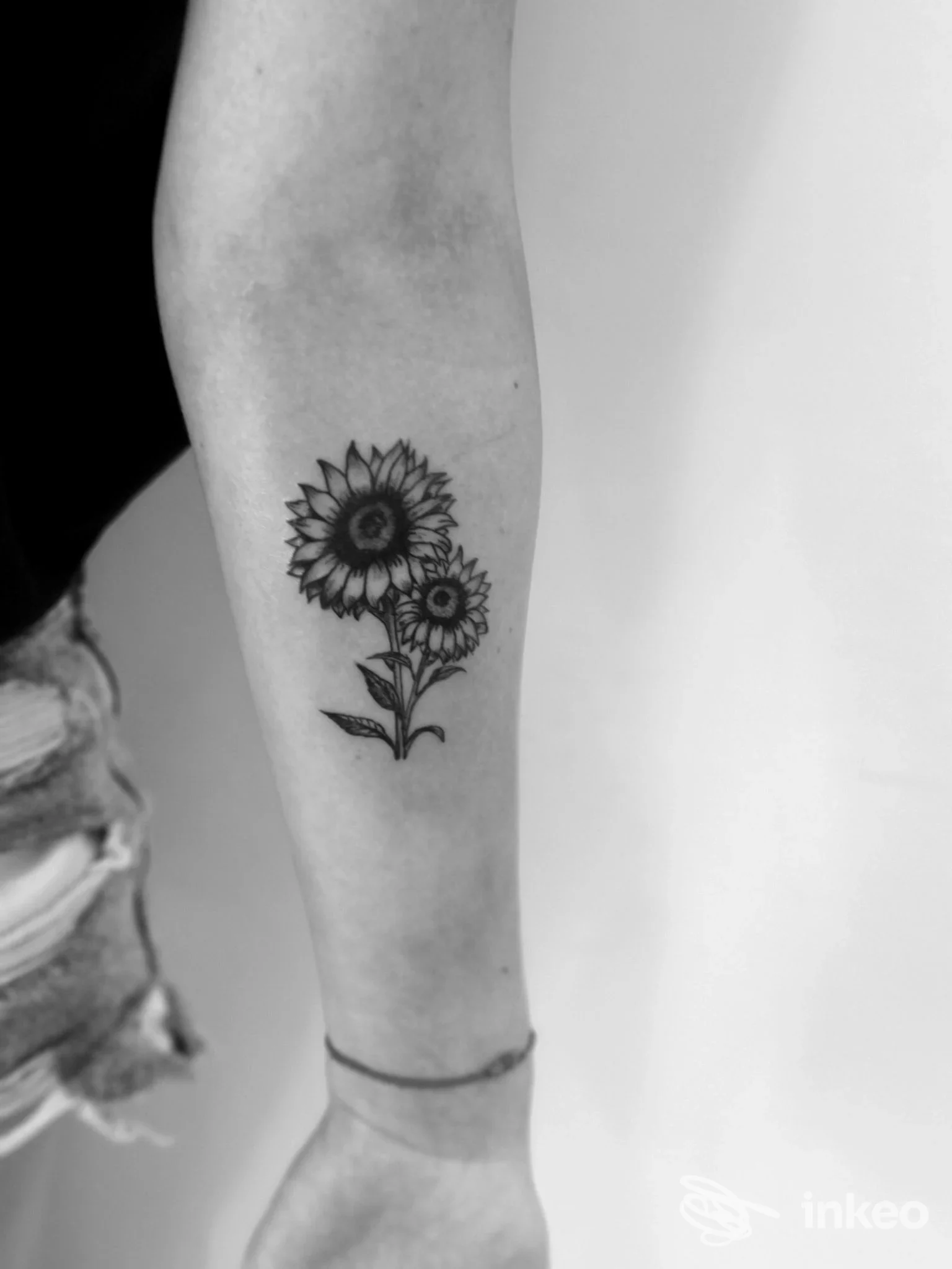 Tatuaggio a inchiostro nero di due girasoli sull'avambraccio, Tatuaggi The Monkey studio a Porto San Giorgio.