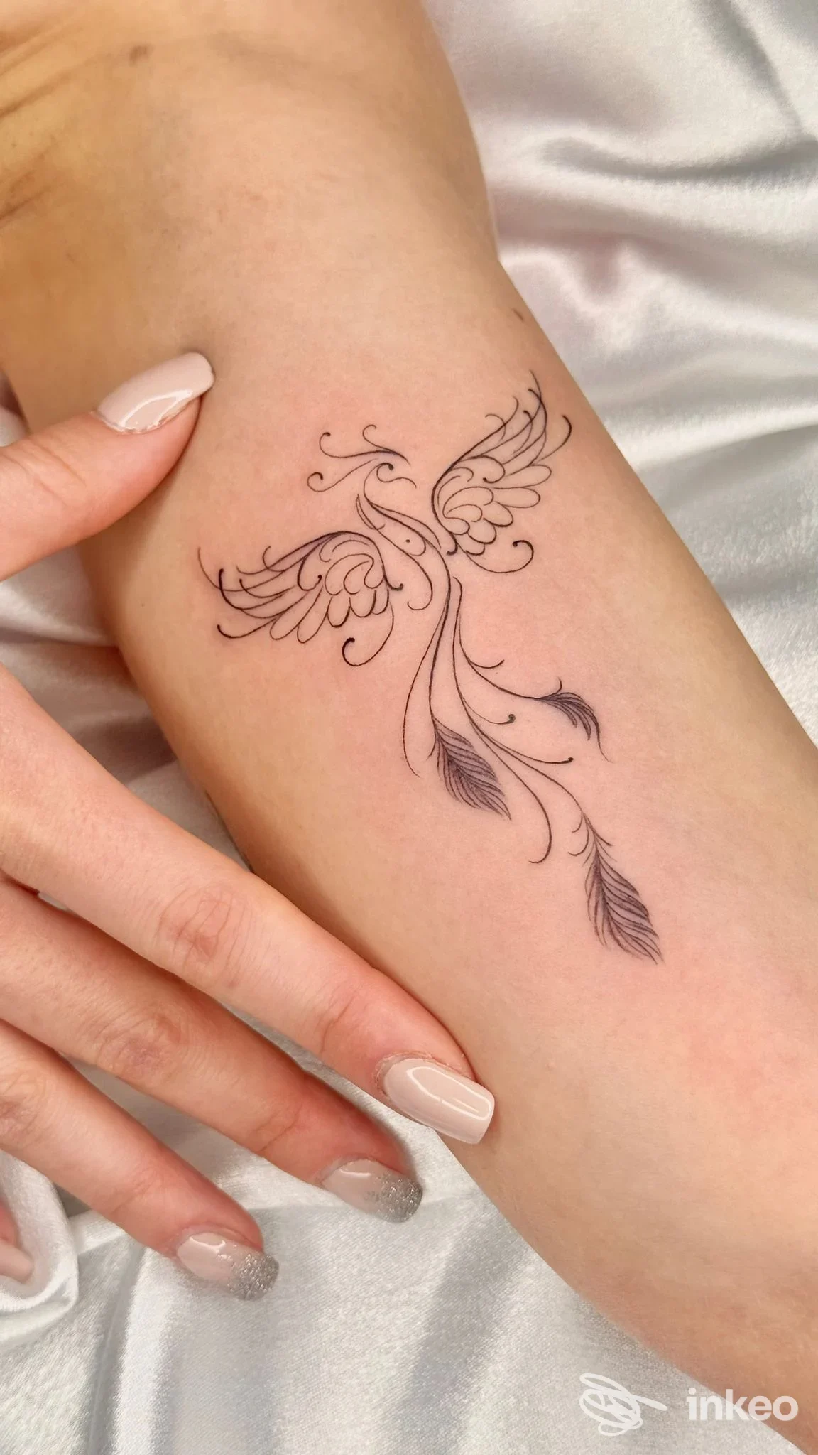 Tatuaggio delicato a forma di fenice sull'avambraccio, fotografato per WHITE ROSE TATTOO a Jesi.