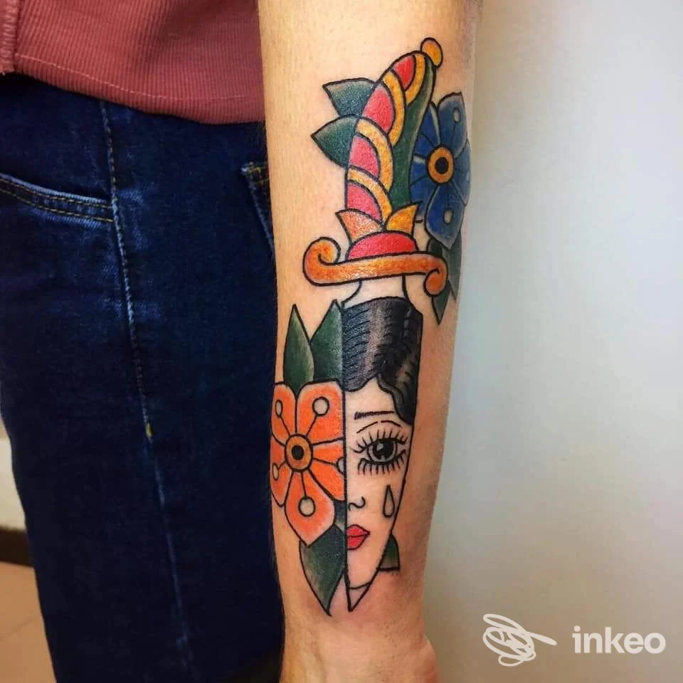 Tatuaggio tradizionale di pugnale con volto sul sottoavampaccio, realizzato da underskintattooshop a Fano.