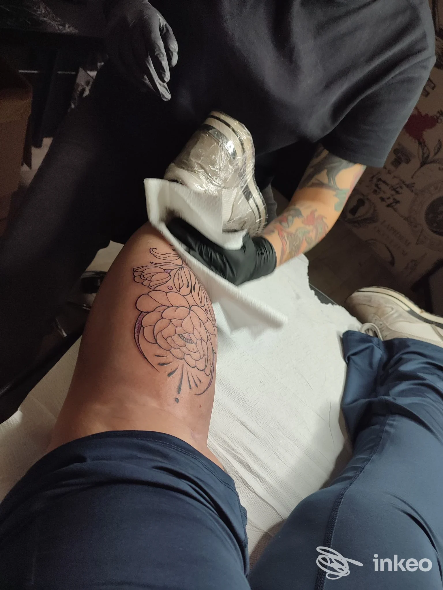 Tatuaggio floreale in corso sulla coscia, artista al lavoro. Black Point Tattoo, Termoli.