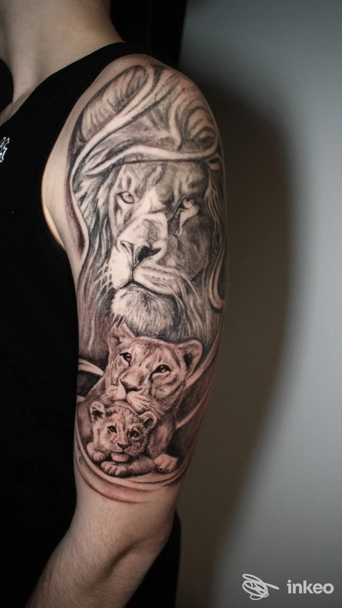 Manica tatuata in bianco e nero con tre teste di leone sul braccio superiore, foto per La Suerte Tattoo Studio, Campobasso.
