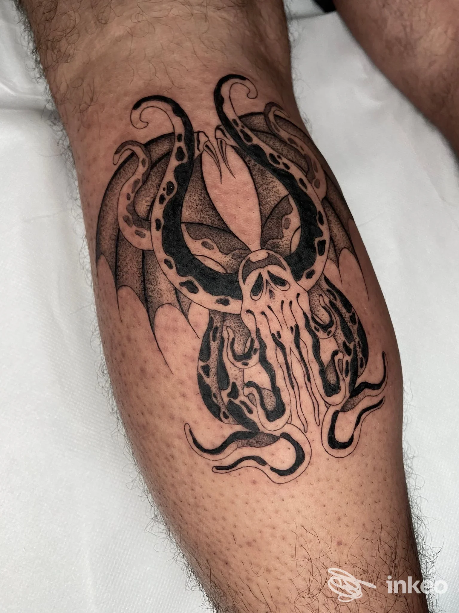 Tatuaggio nero su polpaccio con creatura tentacolare a Fine Line Cutting tattoo shop, Campobasso.