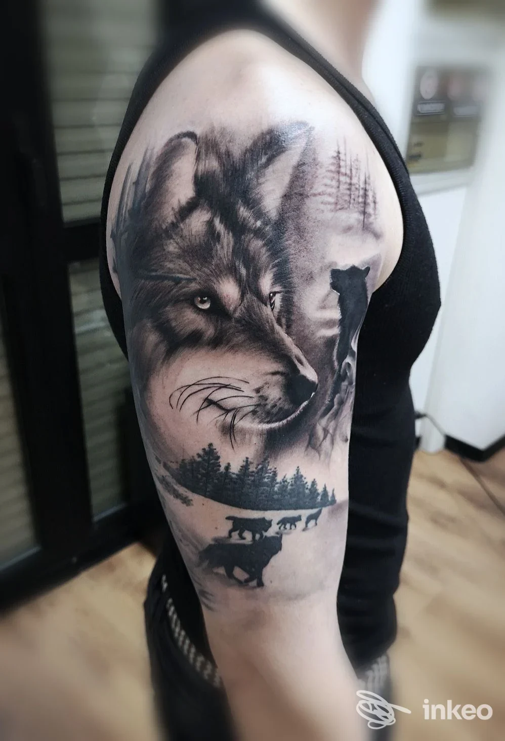Tatuaggio realistico di un lupo sul braccio superiore, fotografato presso Alex Fascio NOVUS tattoo studio a Torino.