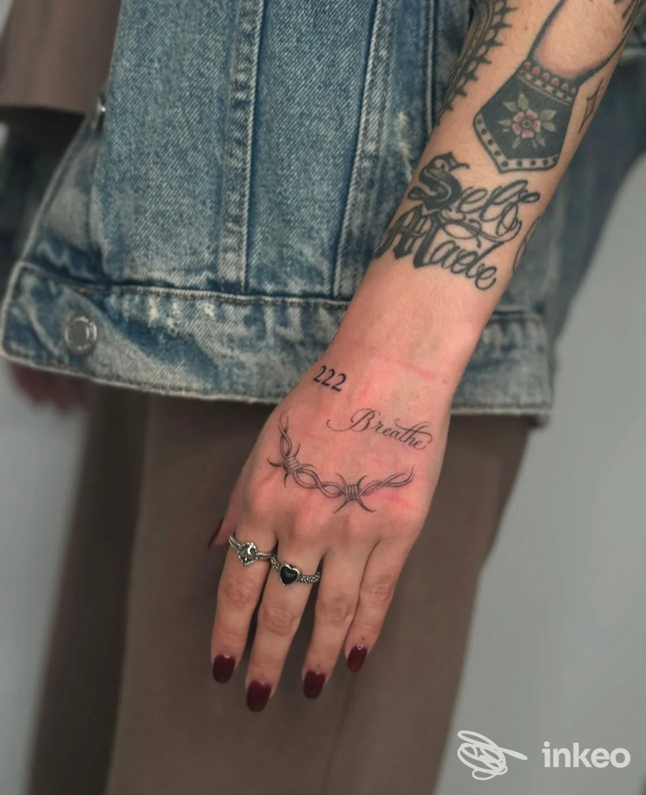 Mano e avambraccio tatuati in primo piano, con lettering e motivi ornamentali. Foto per Alma Libre Tattoo Studio, Casale Monferrato.
