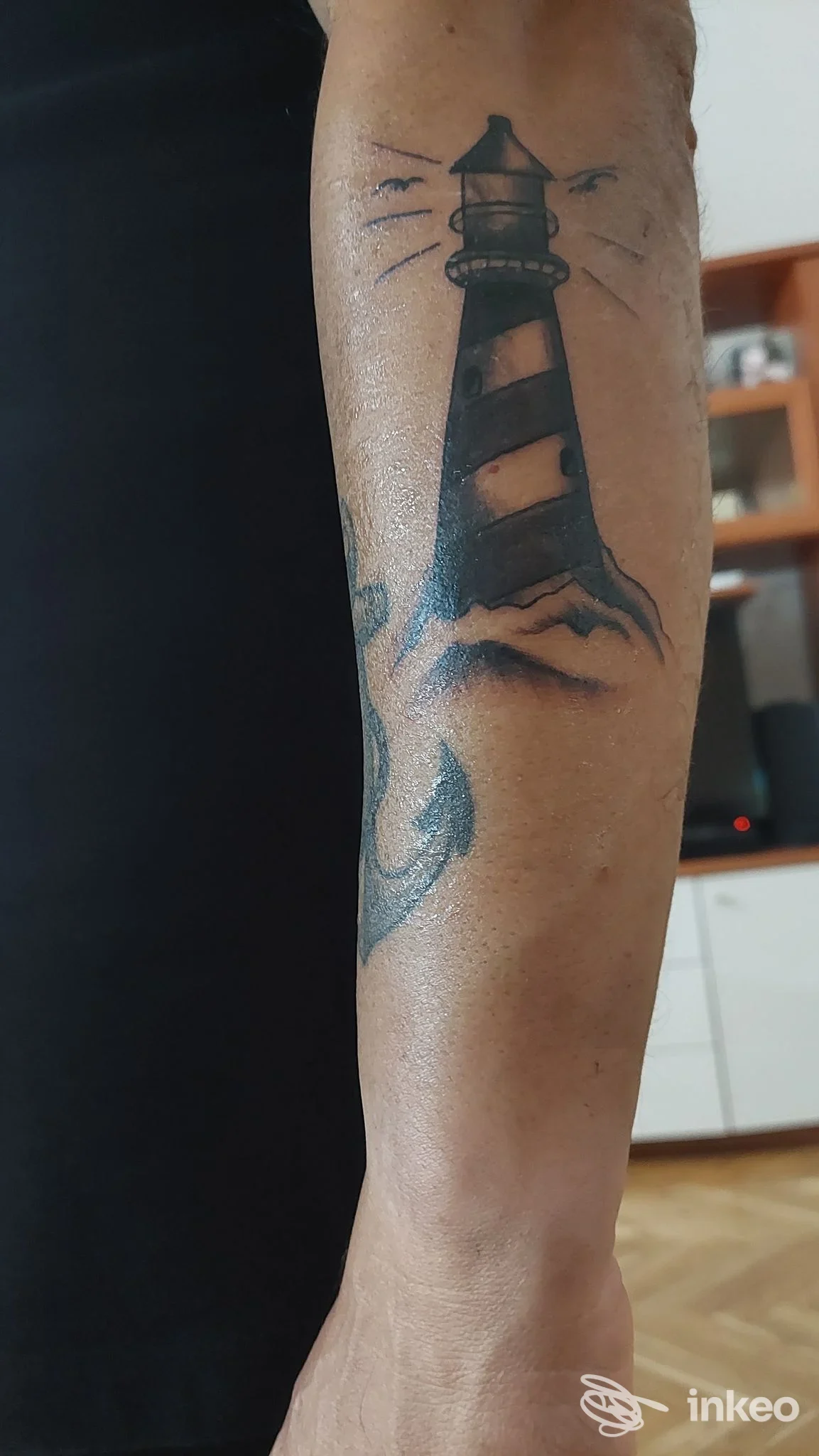 Tatuaggio nero a forma di faro e parte di un'ancora sull'avambraccio, foto inviata da Gold Tattoo Torino, Turin.