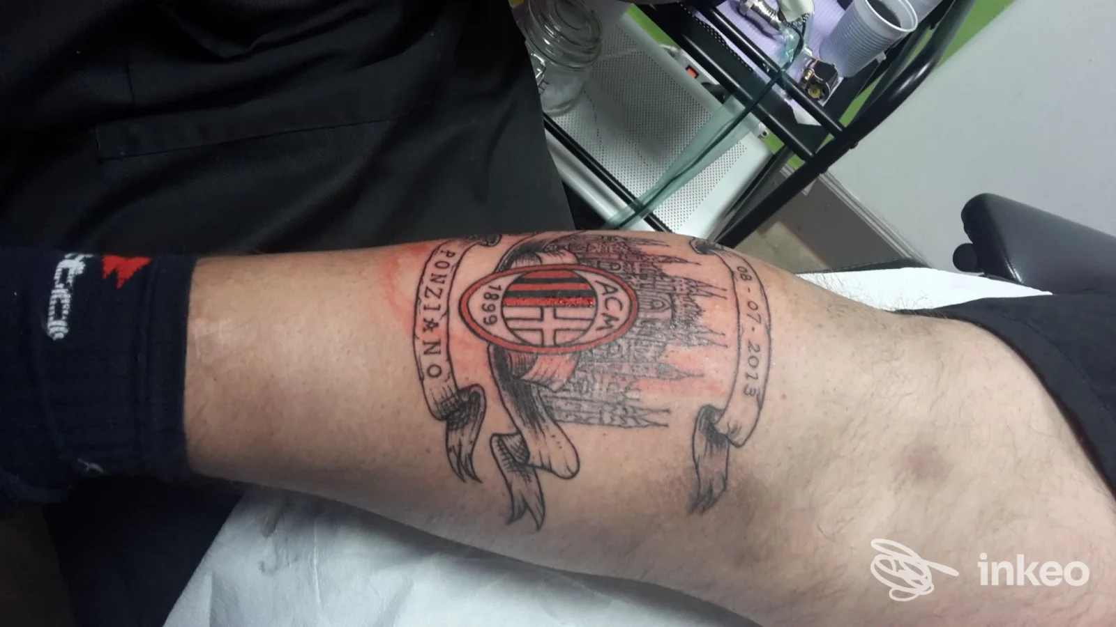 Tatuaggio in bianco e nero su avambraccio mostrato nello studio Gold Tattoo Torino, foto scattata a Turin con dettagli architettonici e stemma.