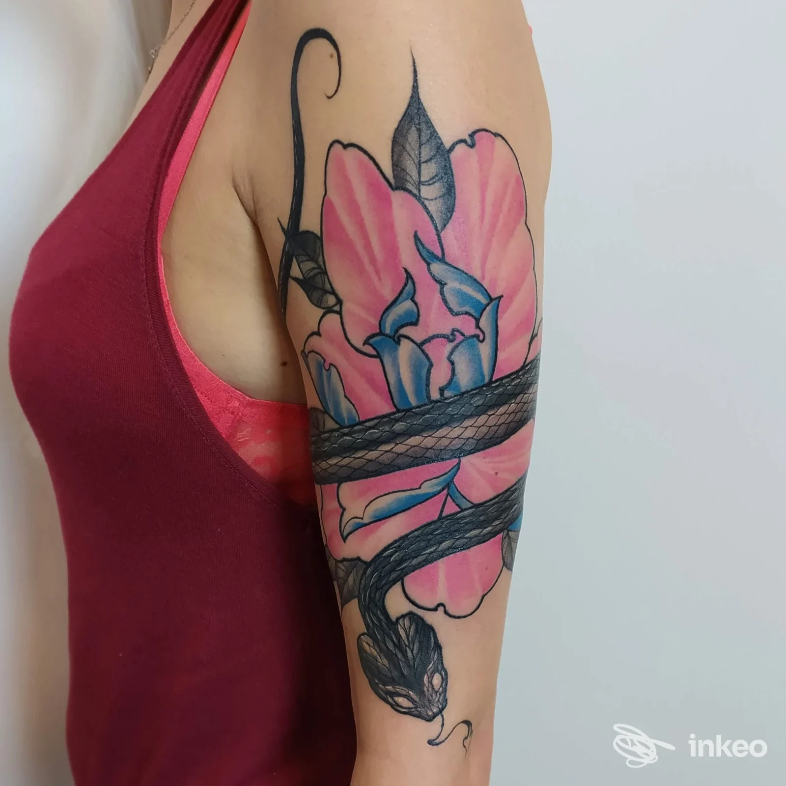 Tatuaggio floreale con serpente avvolto sull'avambraccio, foto fornita da Al 3 tattoo studio, Biella.
