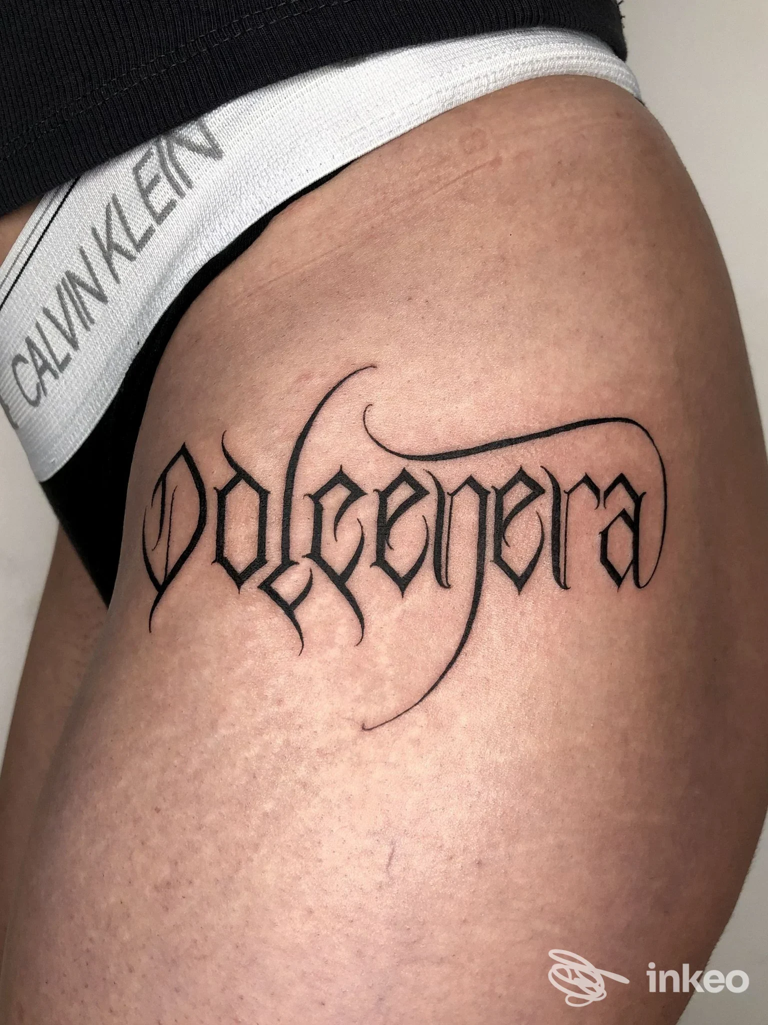 Tatuaggio lettering nero sul fianco/coscia, foto documentativa per Amanita Tattoo & piercing, Torino.