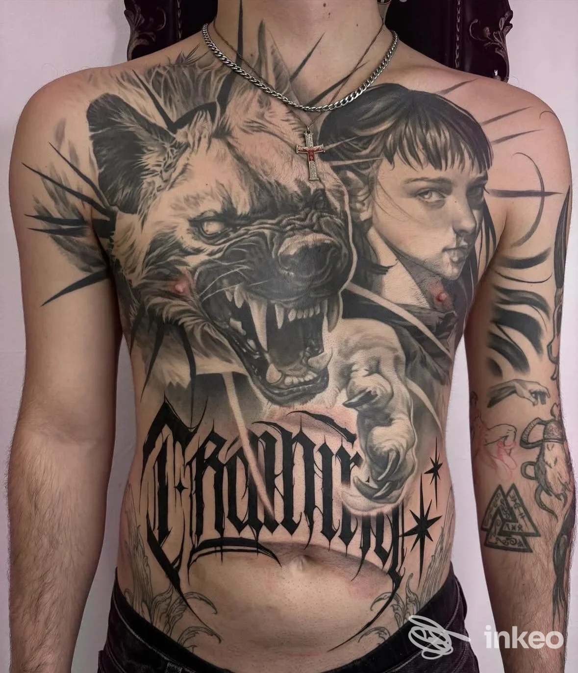 Ampio tatuaggio in bianco e nero su torace e addome con lupo ringhiante e ritratto; Amanita Tattoo & piercing, Torino.