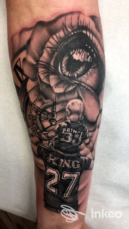 Tatuaggio realistico in bianco e nero su avambraccio con occhio dettagliato, ingranaggi e figure con maglie; Ars Tattoo, Moncalieri.