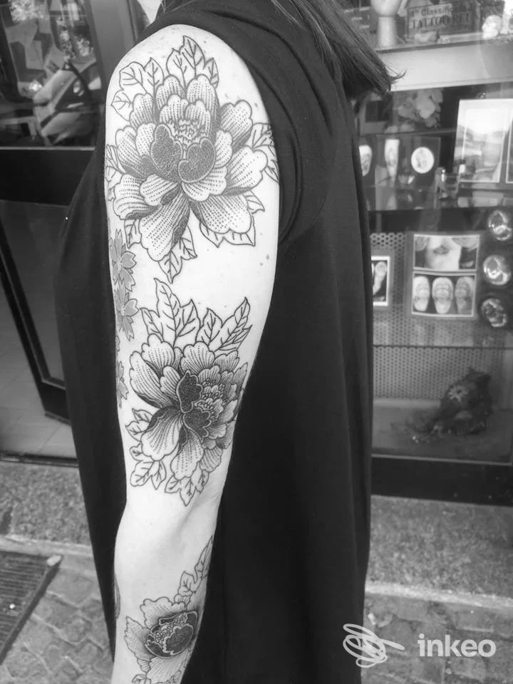 Braccio tatuato con grandi fiori in bianco e nero, foto inviata dallo studio Bibo Tattoo a Dormelletto.