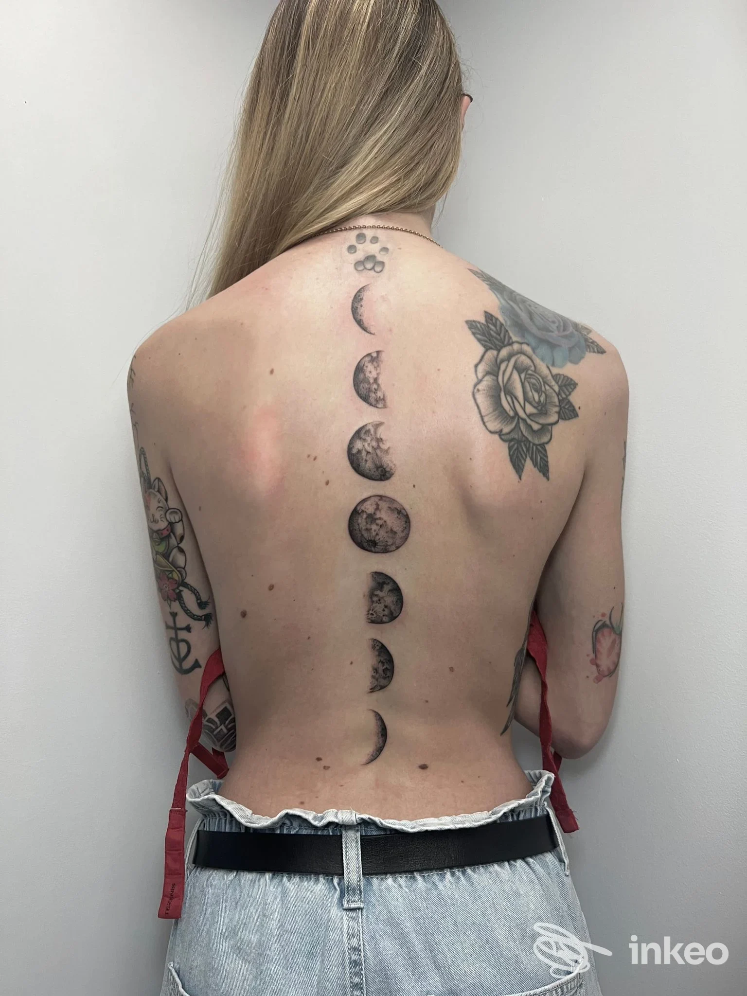 Tatuaggio a fasi lunari lungo la colonna vertebrale su schiena femminile, immagine per BLUEHIDRANGEA TATTOO STUDIO by ALESSIA ZONCO, Biella.
