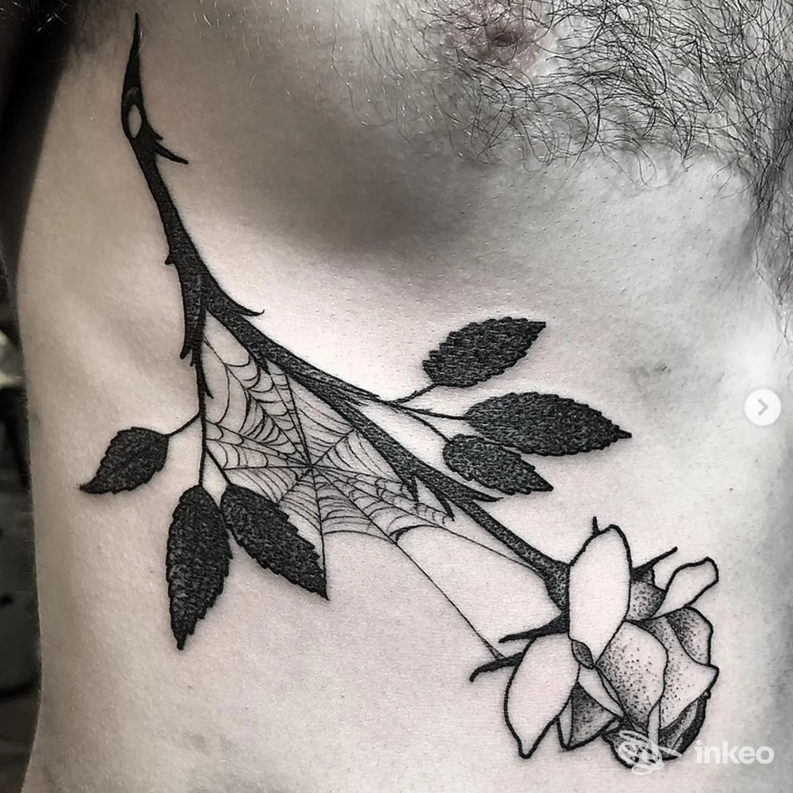 Rosa stilizzata con ragnatela tatuata sul torace/fianco, realizzata da Bad Brains Tattooing a Ivrea.
