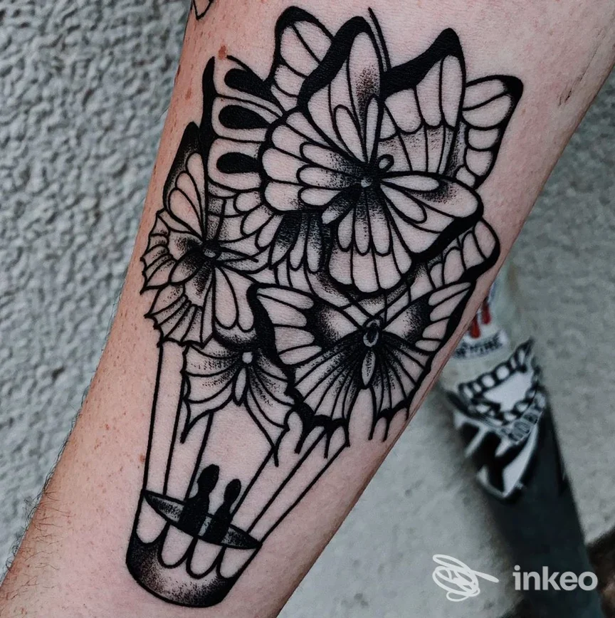 Tatuaggio blackwork su avambraccio con farfalle che formano una mongolfiera, scatto del lavoro realizzato da Bad Brains Tattooing a Ivrea.