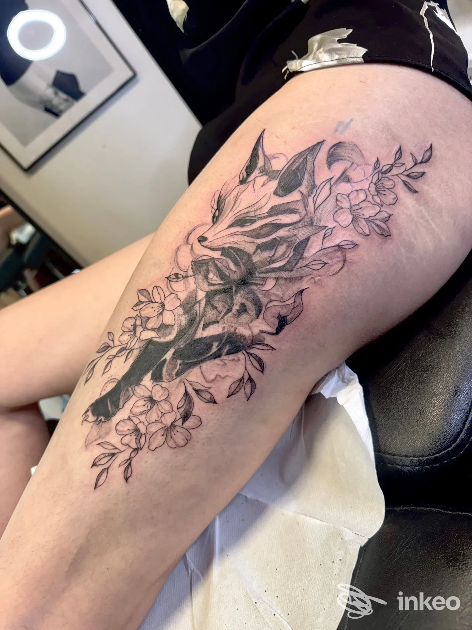 Tattoo su braccio con figura animale e fiori, tatuaggio nero in lancette, eseguito su pelle reale.