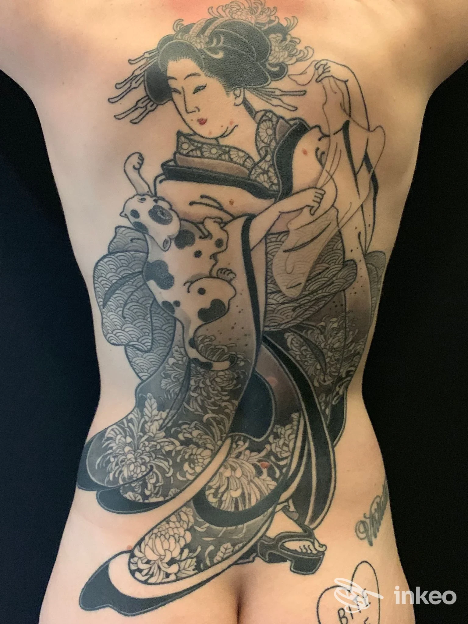 Ampio tatuaggio sul dorso raffigurante una figura in stile giapponese con motivi floreali, scatto da Becchi Tattoo Cluster Studio, Torino.