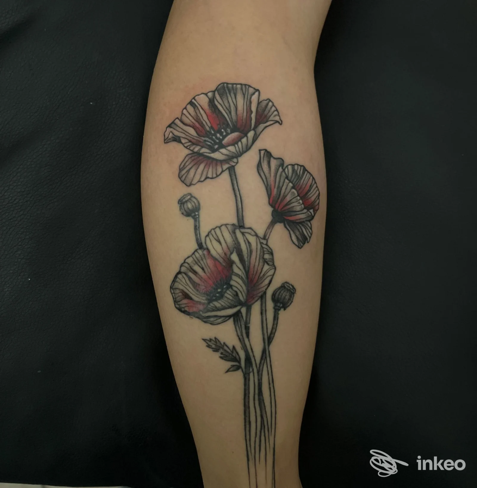 Tatuaggio di papaveri sull'avambraccio, linea nera con riempimenti rossi, realizzato da Blink Studio Tattoo a Torino.
