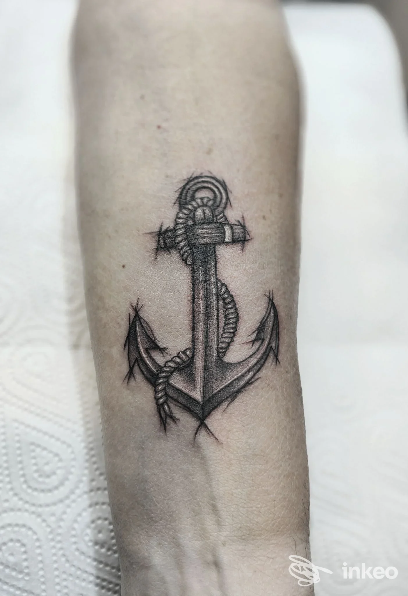 Tatuaggio a inchiostro nero di un'ancora sull'avambraccio, eseguito da Blink Studio Tattoo a Torino, vista ravvicinata del lavoro.