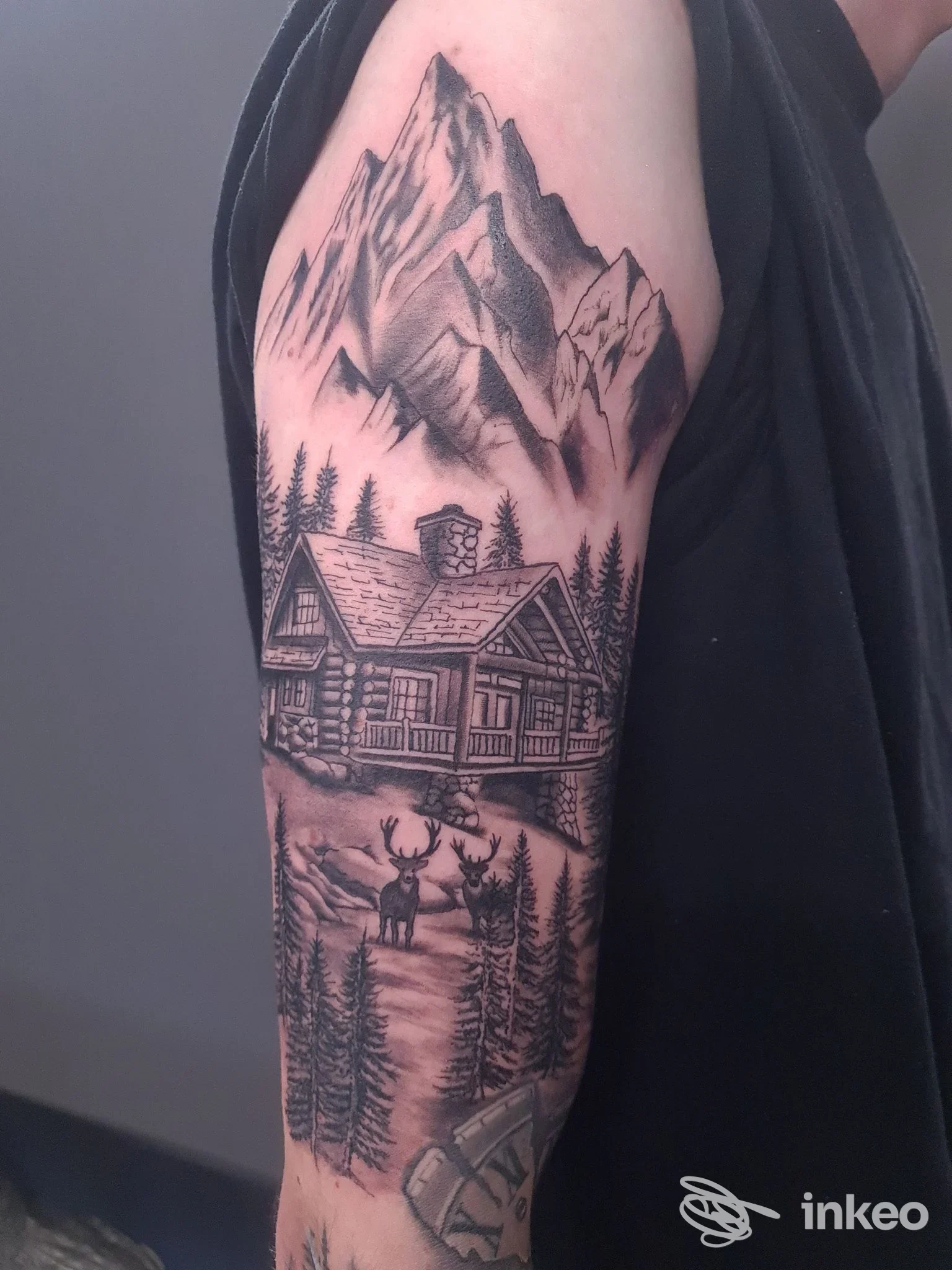 Tatuaggio a manica con paesaggio montano, baita e cervo fotografato su braccio reale, immagine fornita da Bogia Nen!! Tattoo, Condove.