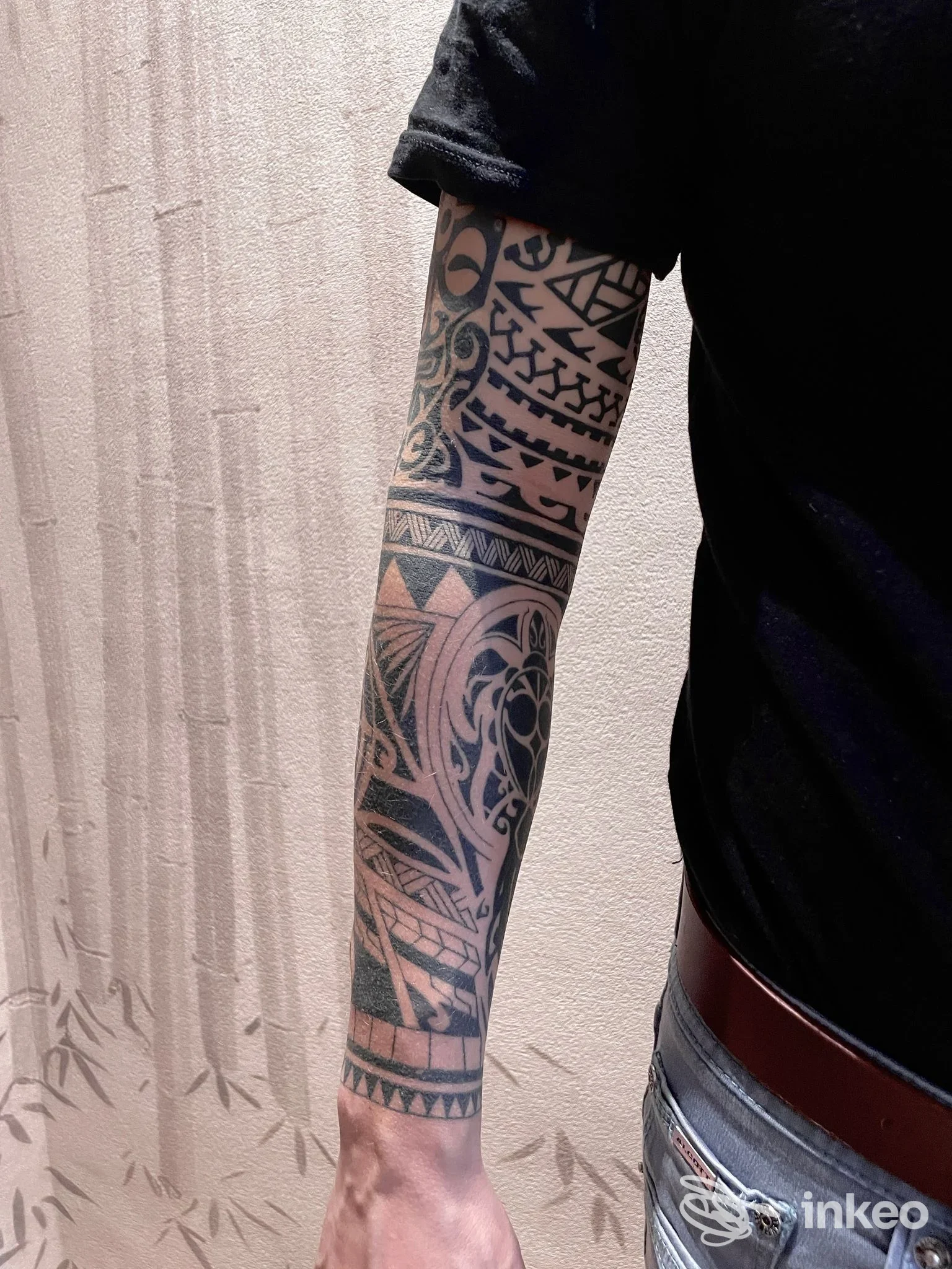 Tatuaggio a manica con motivi tribali sull'avambraccio destro, foto inviata da Crisantemo Tattoo, Torino.