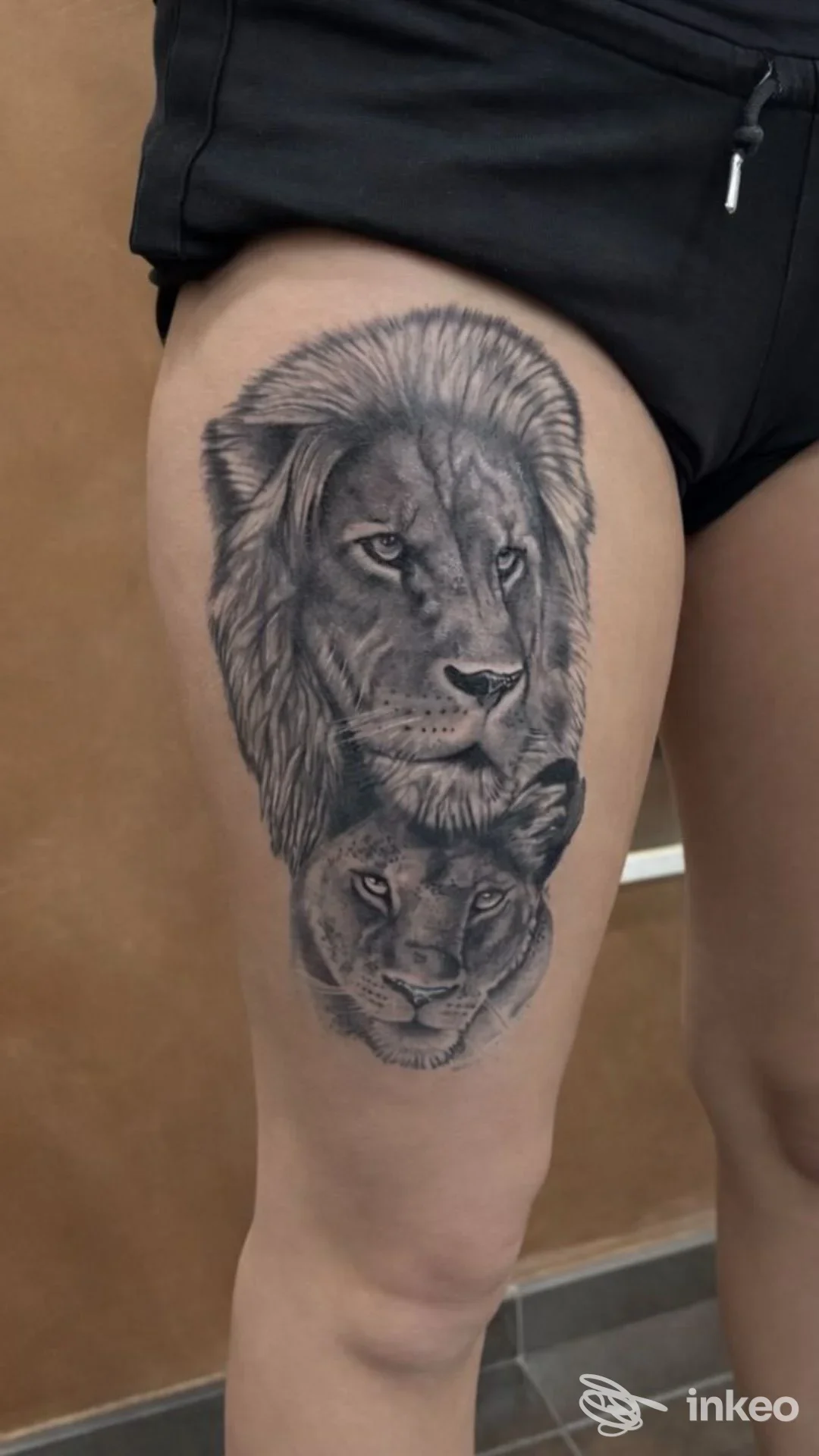 Tatuaggio realistico in bianco e nero con due teste di leone sulla coscia; foto fornita da Danger Tattoo Studio, Torino.