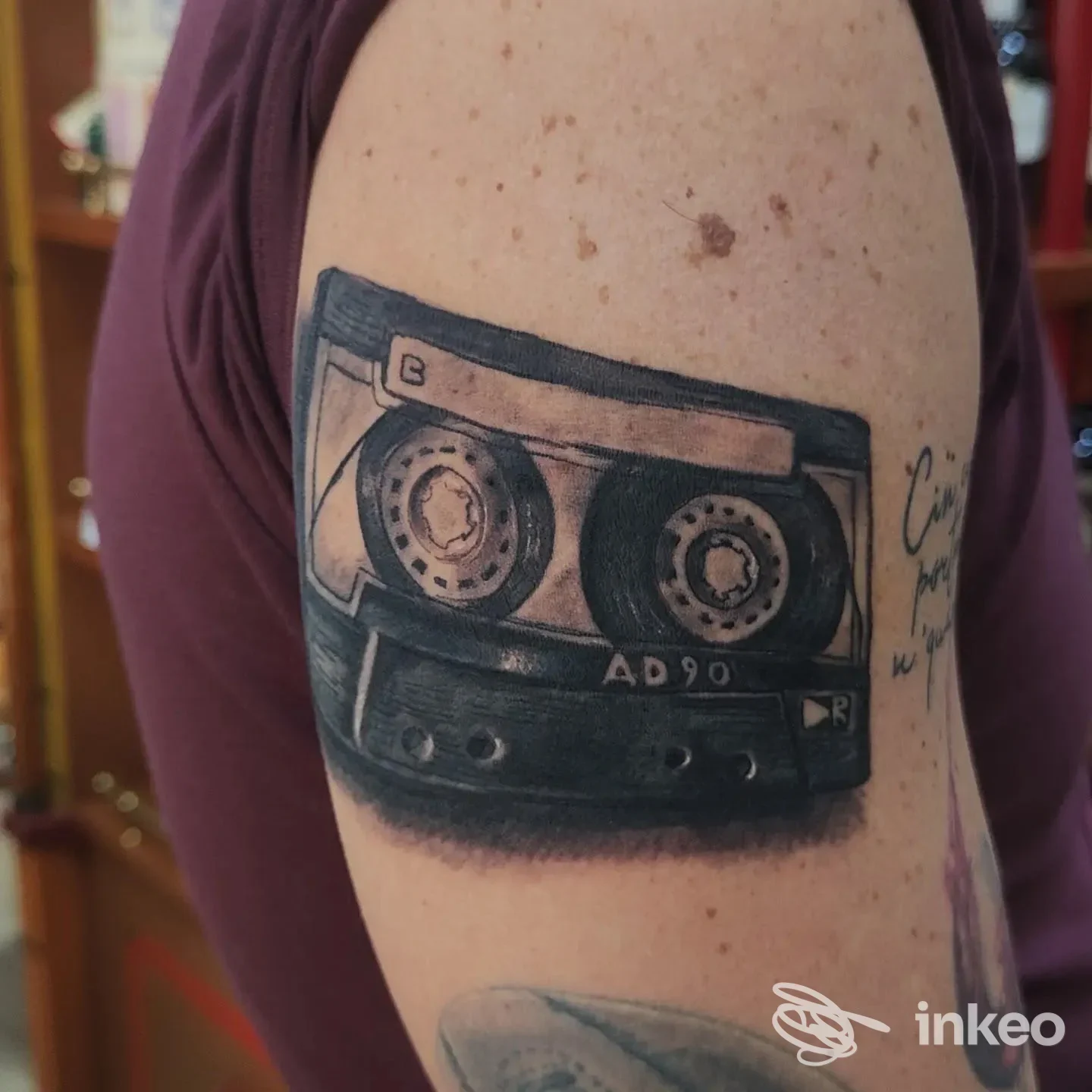 Tatuaggio realistico di una musicassetta sull'omero, immagine fornita da Diem Tattoo, Torino.