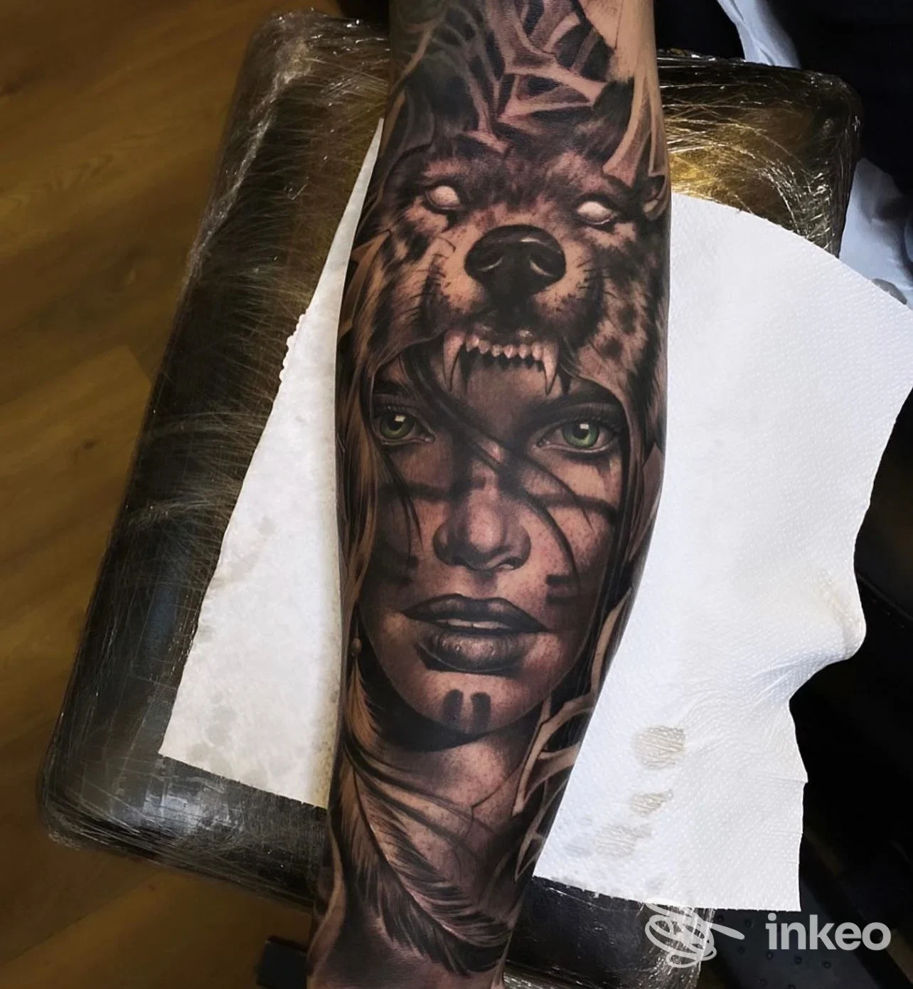 Tatuaggio a manica su avambraccio con lupo e volto femminile realistico, realizzato da Dope Tattoo a Bra.