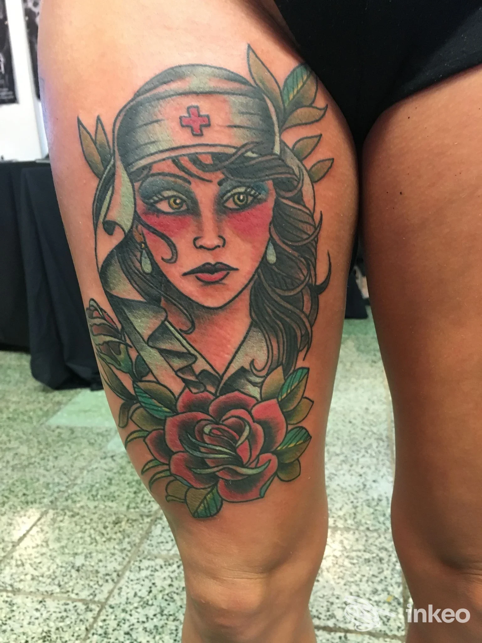 Grande tatuaggio a colori su coscia con volto femminile in fascia sanitaria e rosa, foto pubblicata da Dream Tattoo Fulvio Verdina a Borgosesia.