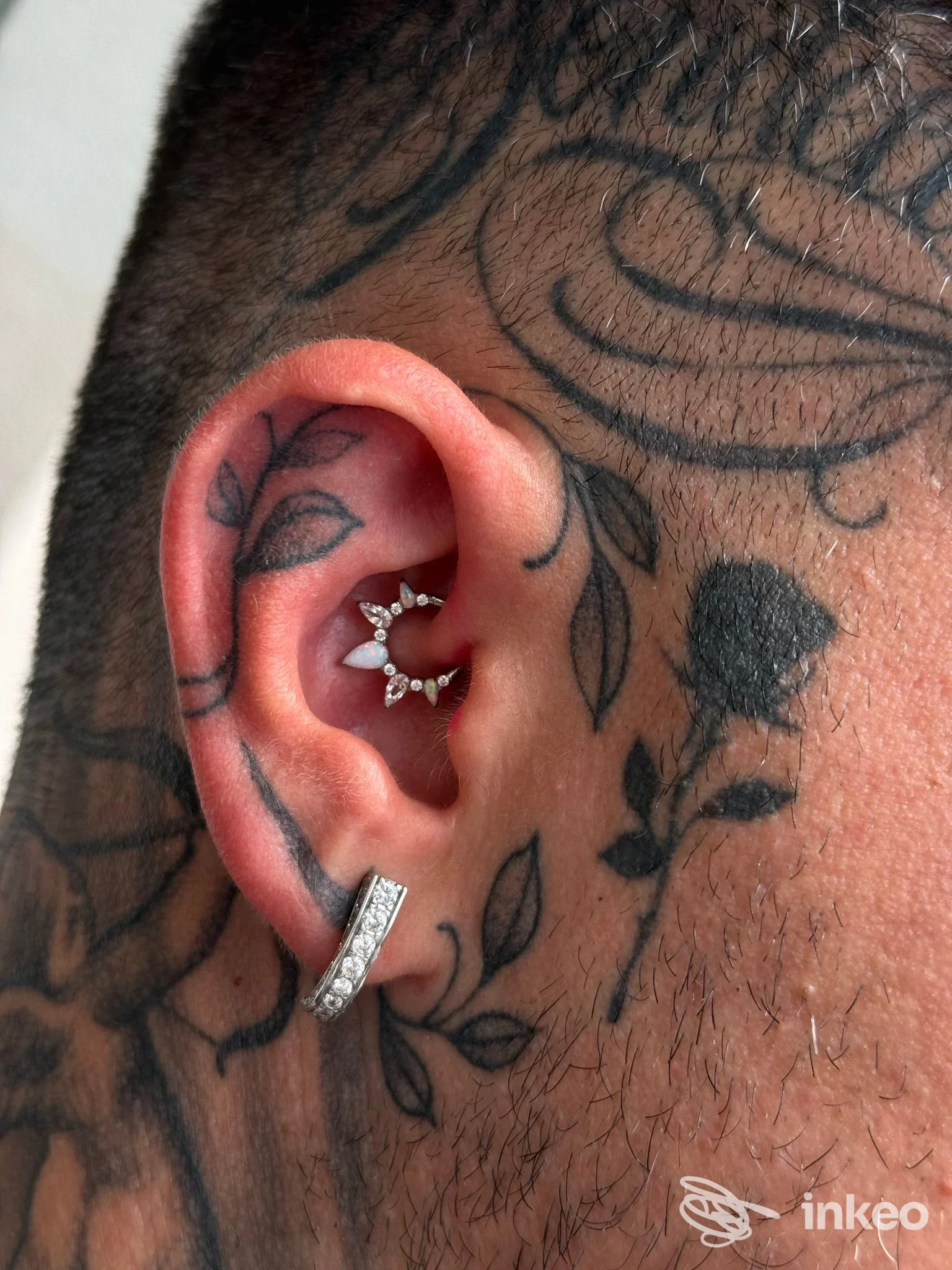 Piercing al padiglione auricolare con gioielli e tatuaggi decorativi sul lato della testa, Elite Luxury Studio Piercing, Chivasso.