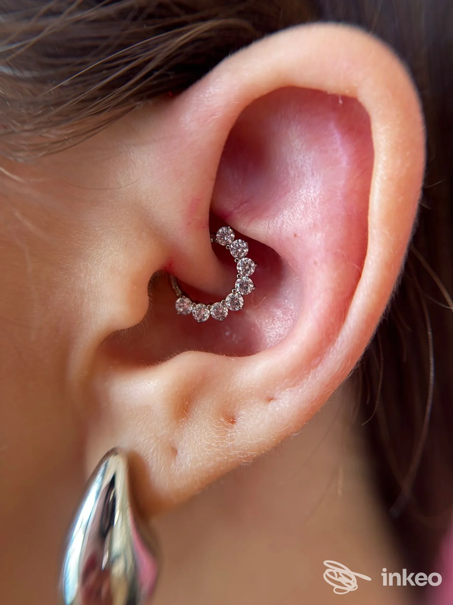 Primo piano di un padiglione auricolare con piercing decorativo a cristalli (daith), foto fornita dallo studio Elite Luxury Studio Piercing, Chivasso.