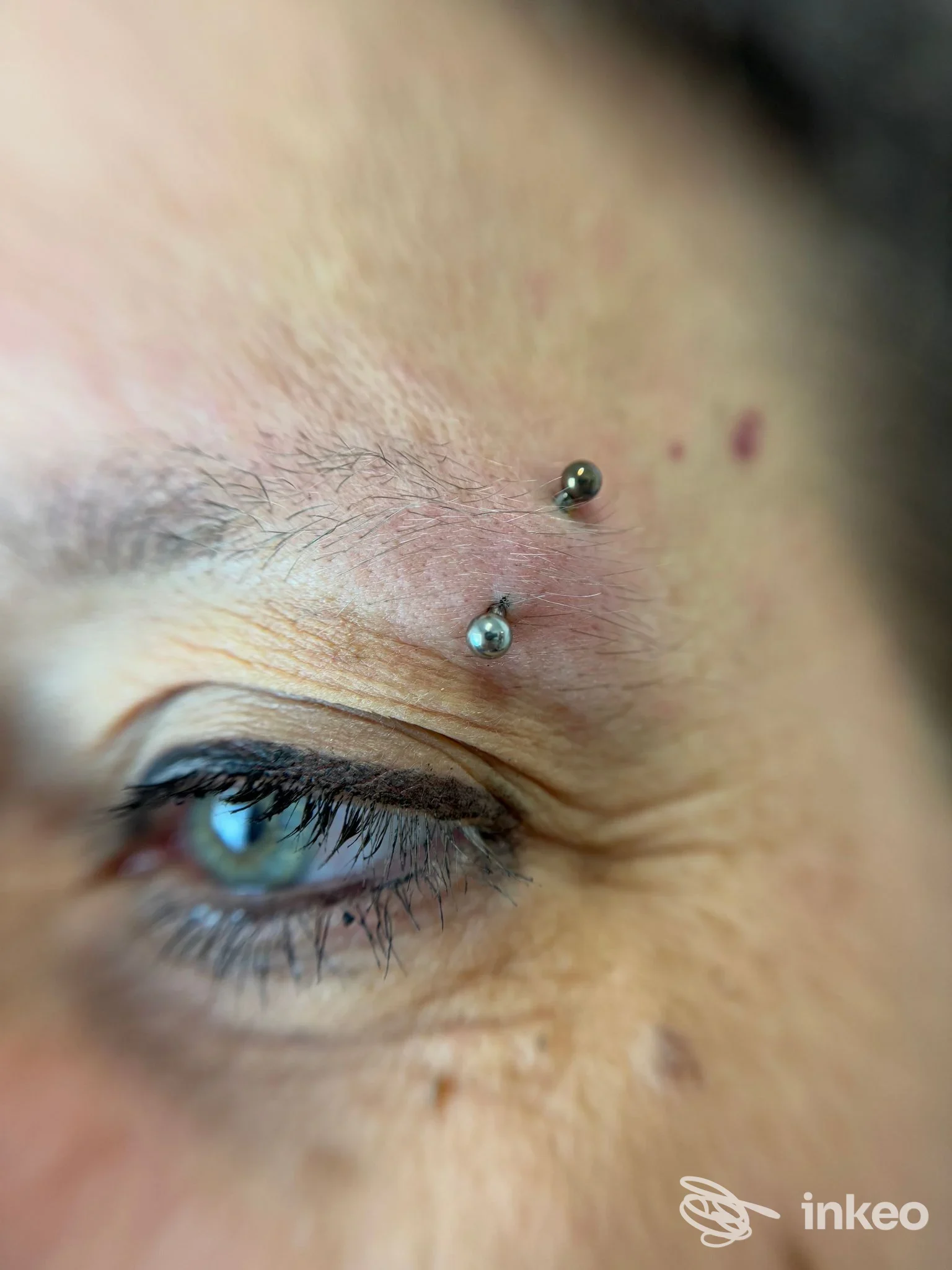 Primo piano di piercing sopra la sopracciglia realizzati da Elite Luxury Studio Piercing a Chivasso.