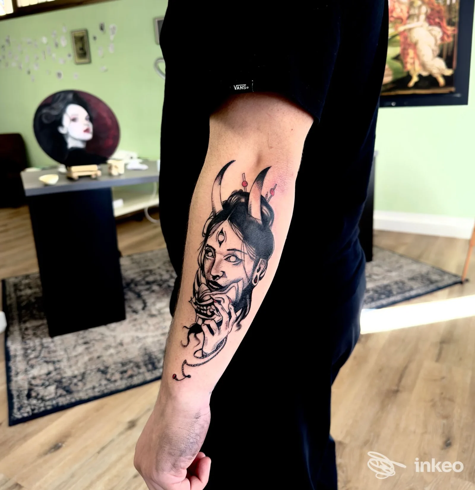 Tatuaggio su avambraccio con volto cornuto in nero e accenti rosa, foto dallo studio Esseink TATUAGGI E PIERCING a Ivrea.