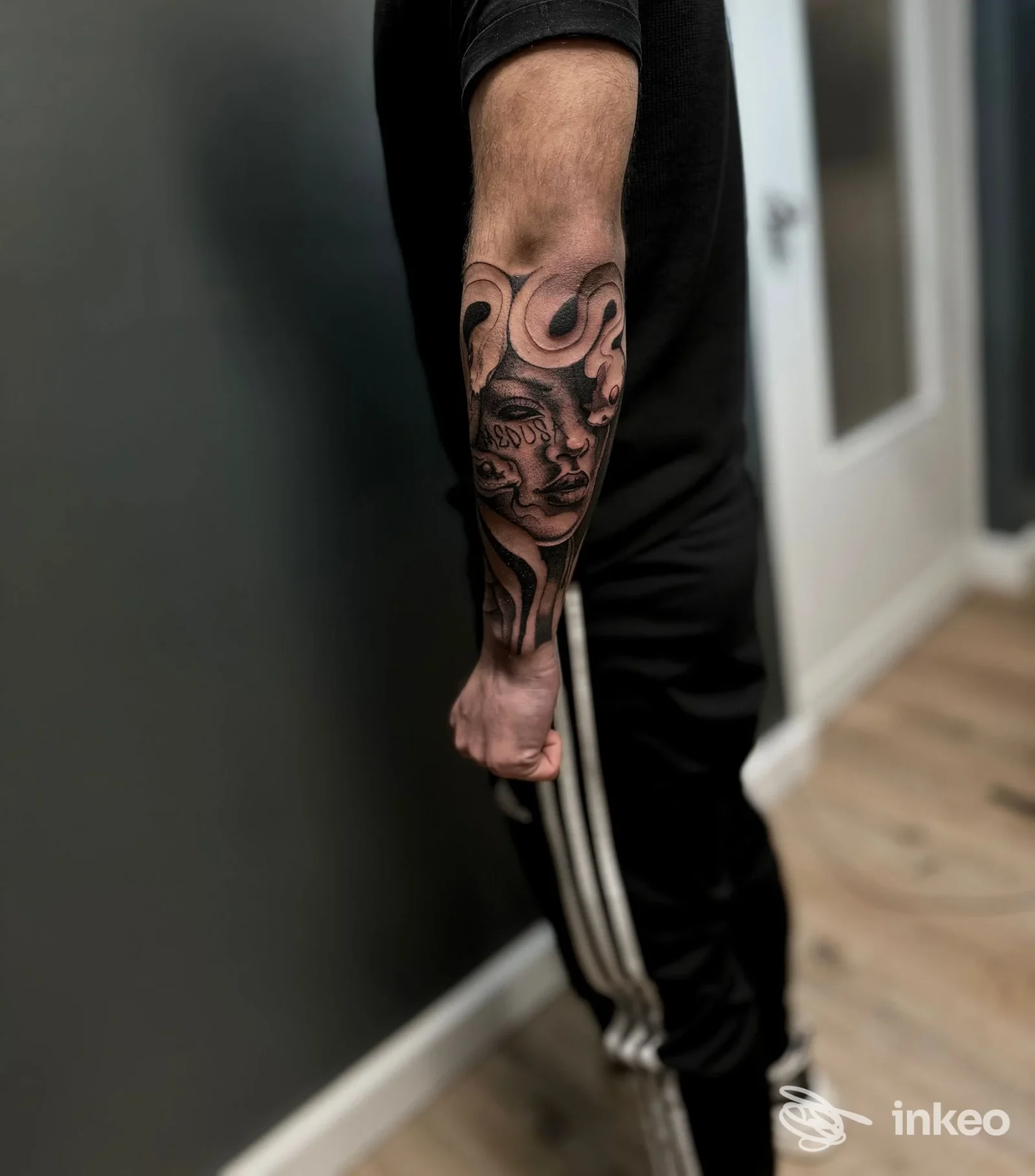 Primo piano dell'avambraccio con grande tatuaggio a volto stilizzato, foto fornita da Esseink TATUAGGI E PIERCING, Ivrea.