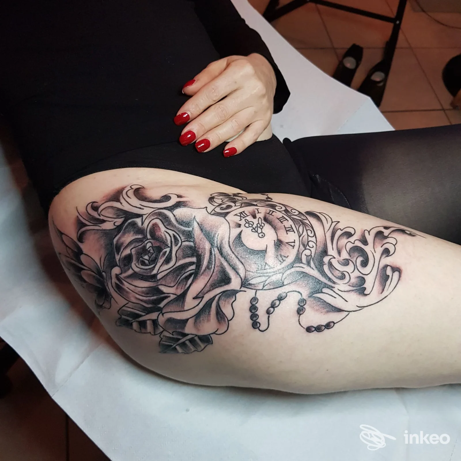 Tatuaggio black & grey su coscia con rosa, orologio da tasca e perline, realizzato da Etien Tattoo a Ivrea.