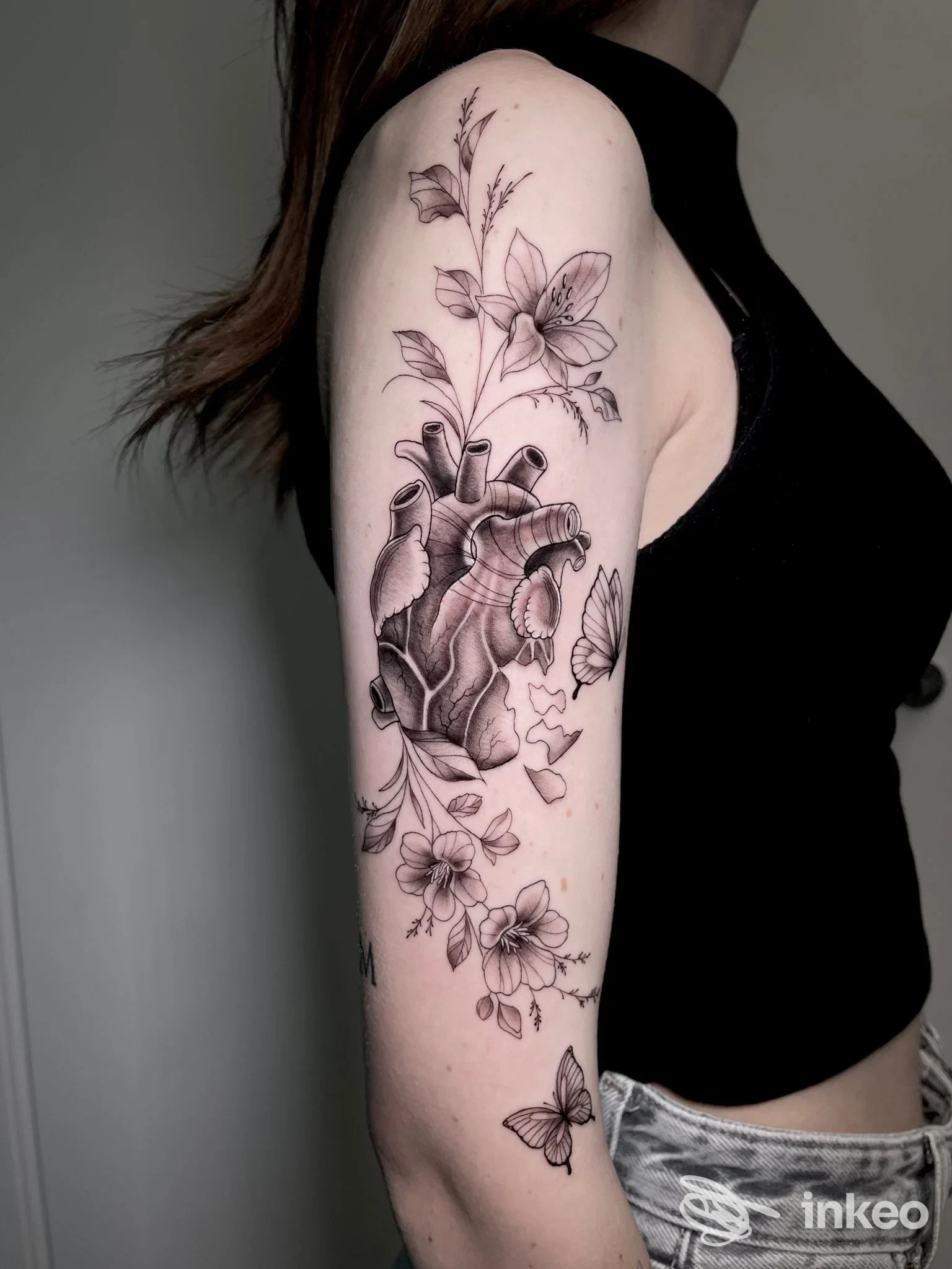 Grande tatuaggio anatomico e floreale sul braccio superiore, fotografato per Fishbone Tattoo studio a Chieri.