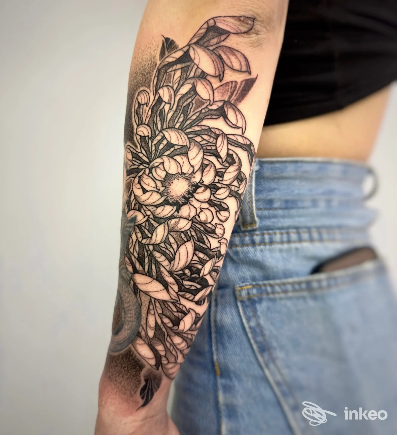 Primo piano di un tatuaggio floreale in nero sull'avambraccio, foto fornita da Felvo Tattoo Studio, Torino.