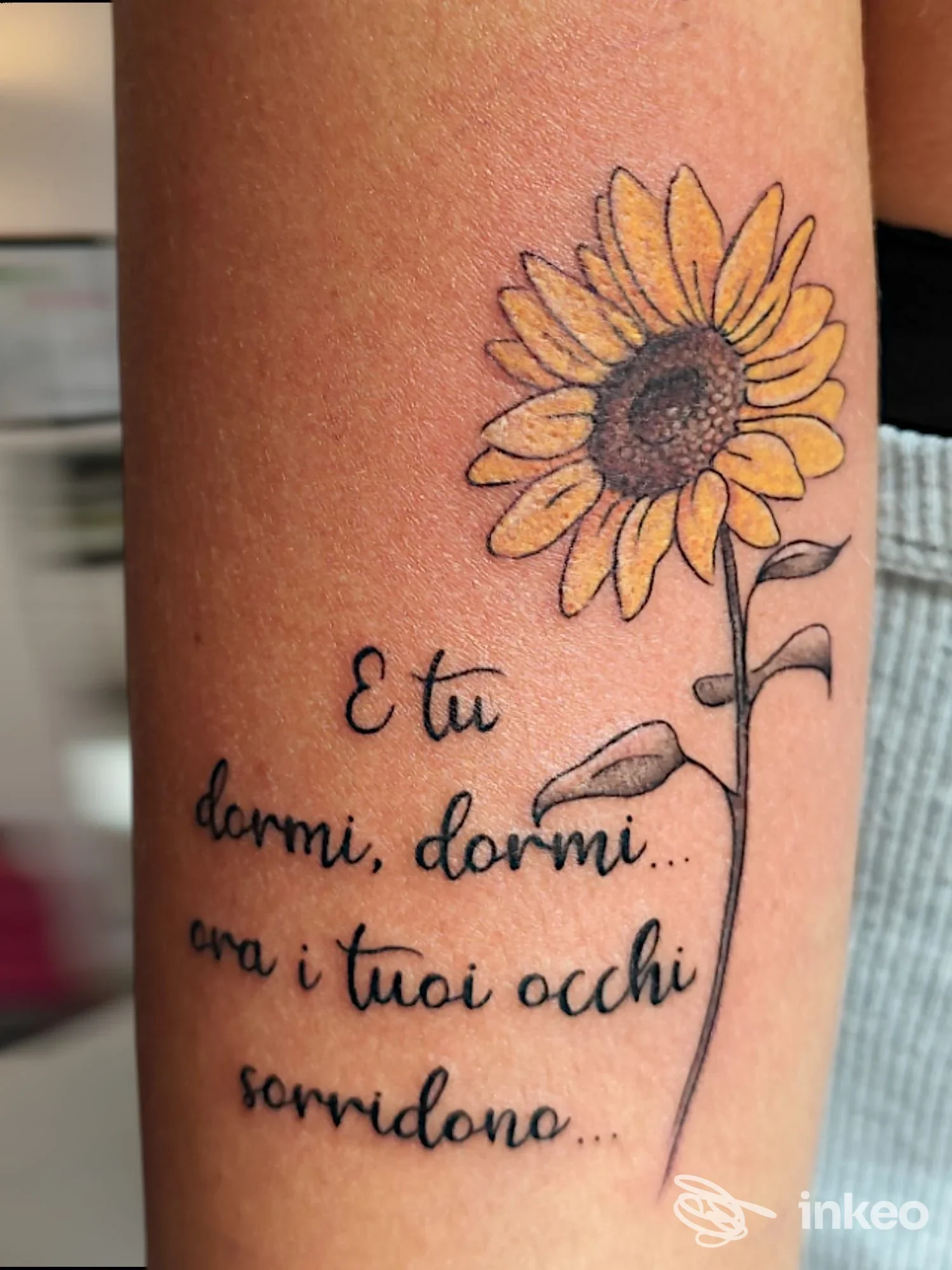 Tatuaggio su avambraccio con girasole colorato e testo in corsivo, Futura tattoo studio – Cuorgnè.