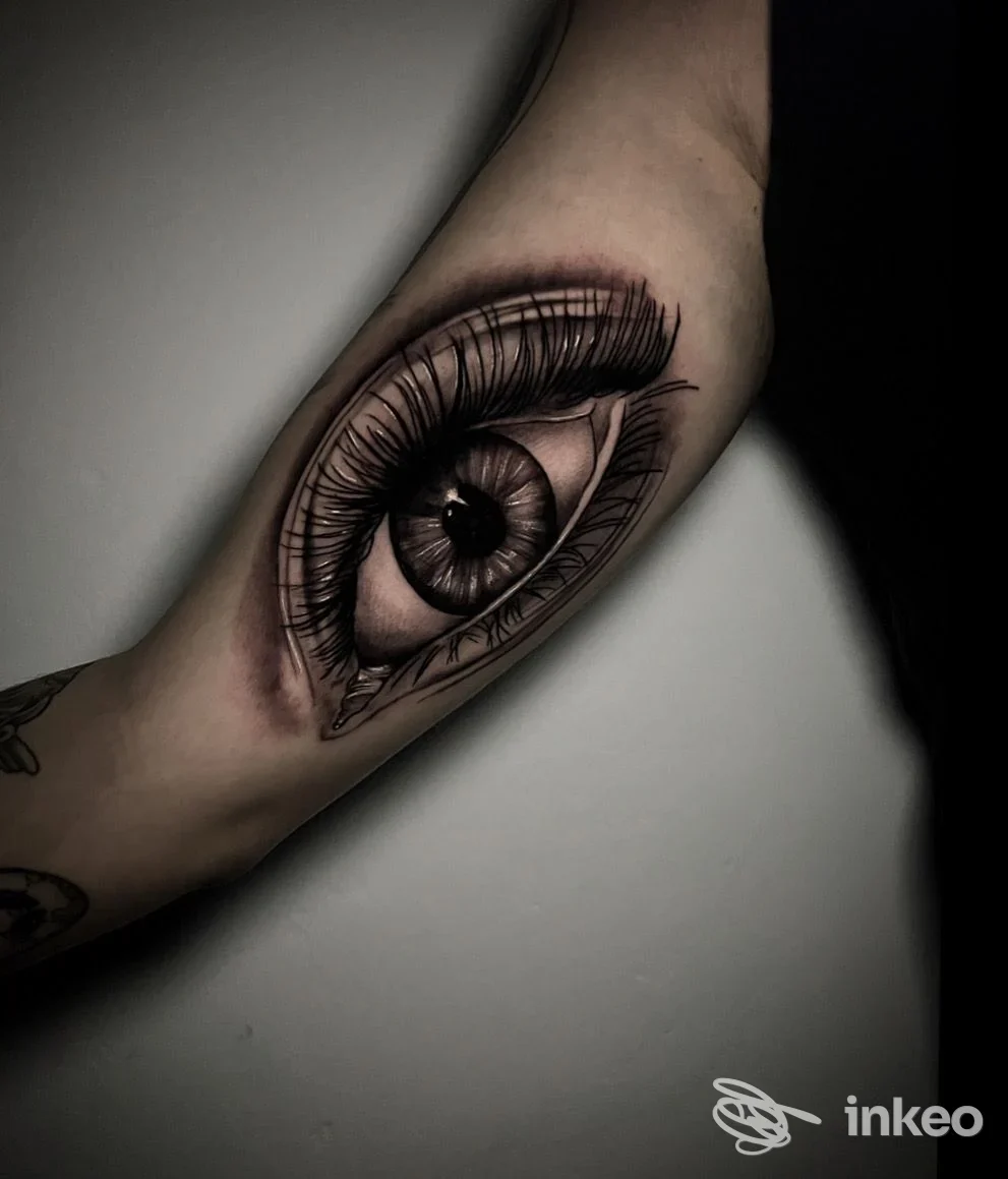 Tatuaggio realistico a forma di occhio sull'avambraccio interno, con dettagli di iride e ciglia ben definiti. Hazard Tattoo Studio, Torino.