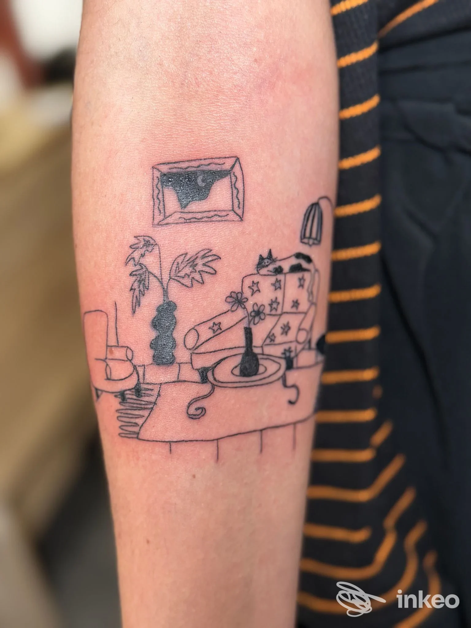 Tatuaggio lineare su avambraccio raffigurante un interno domestico stilizzato, immagine fornita da HAPAX - Tattoo & Piercing, Torino.